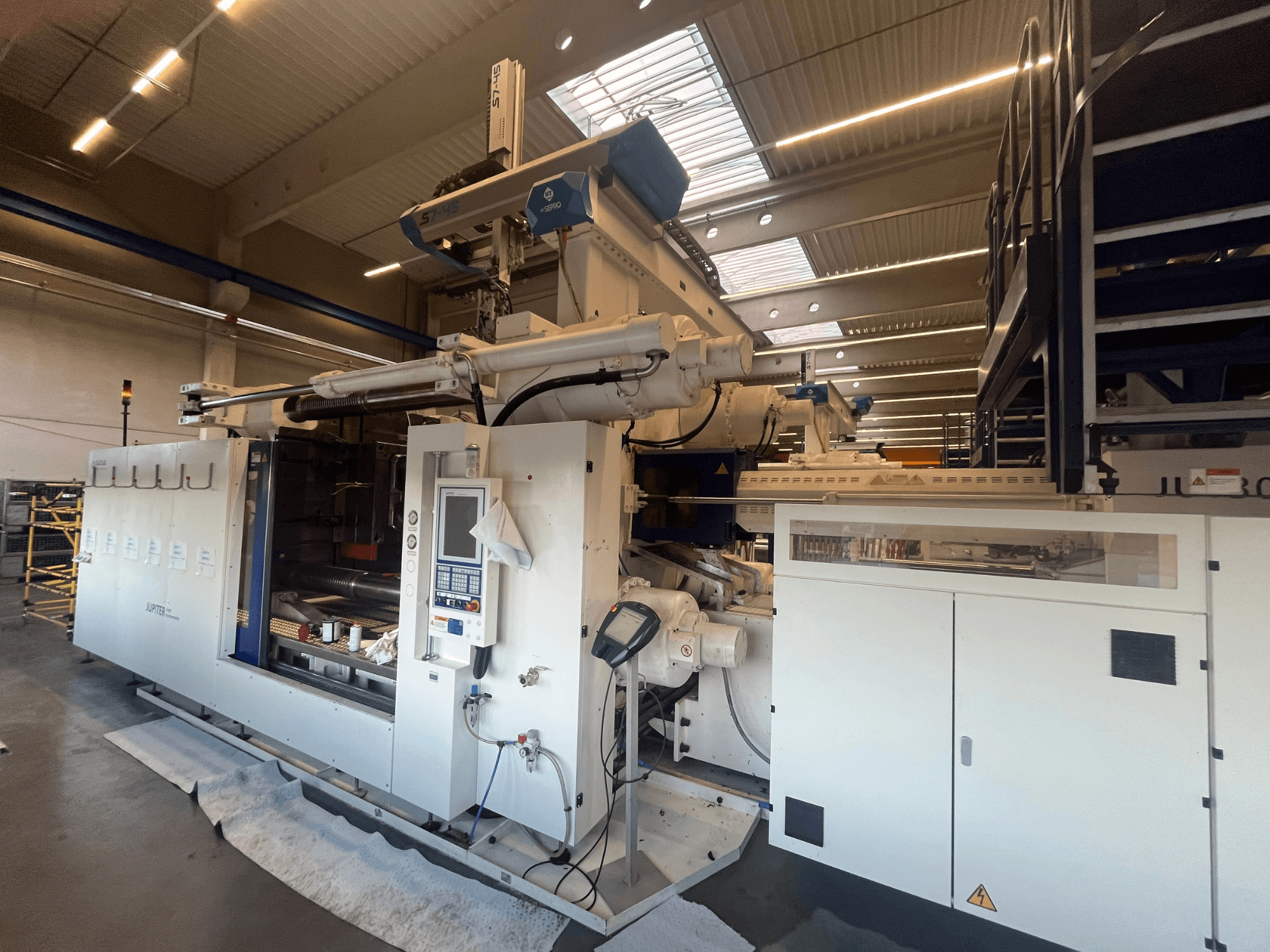 Prednji pogled na tekstilni stroj Autefa, s upravljačkom pločom, komponentama i industrijskim okruženjem.