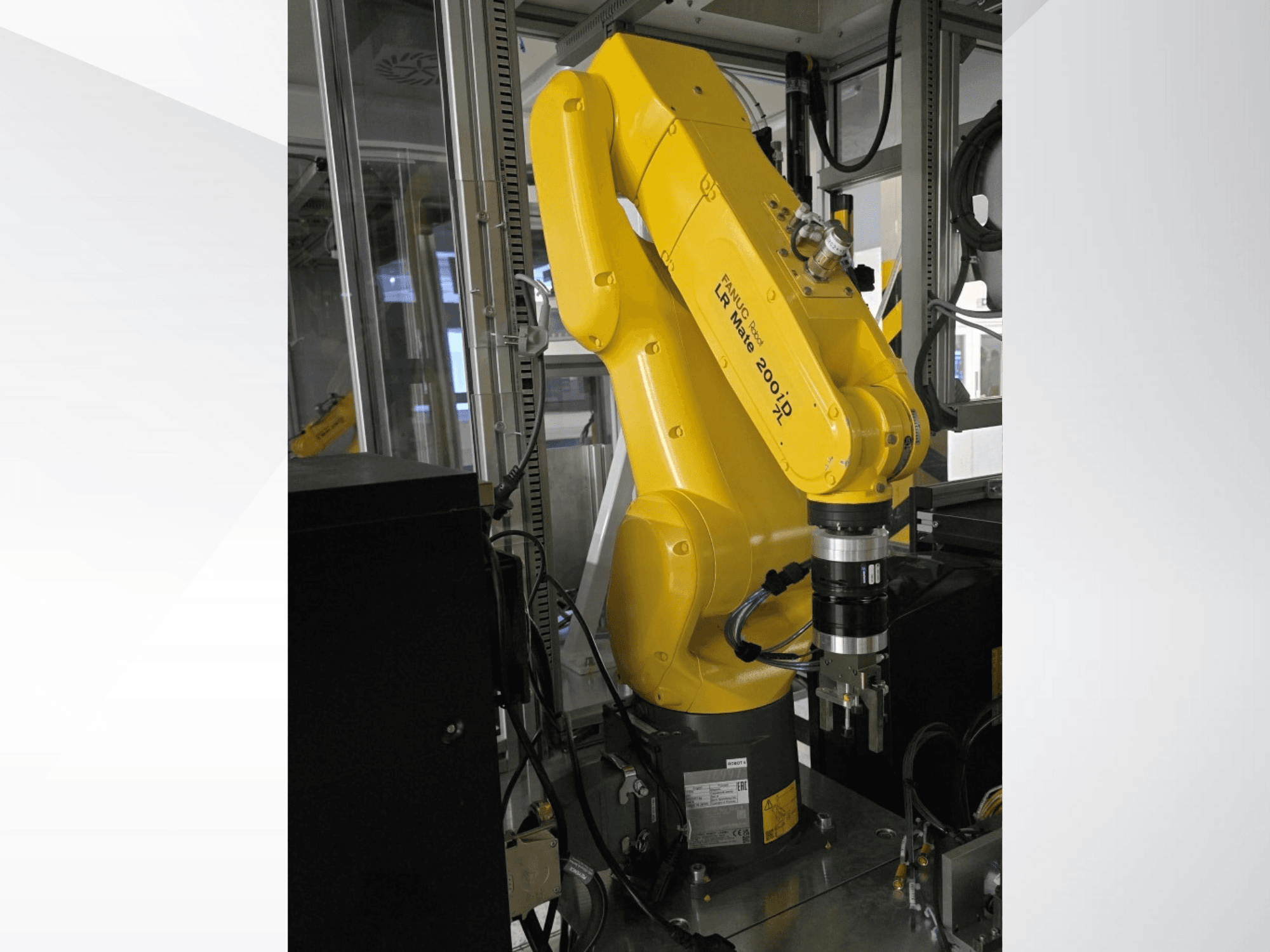 Žuta robotska ruka Fanuc LR Mate 200iD prikazana iz bočnog pogleda, s hvataljkom i raznim pričvršćenim kabelima.