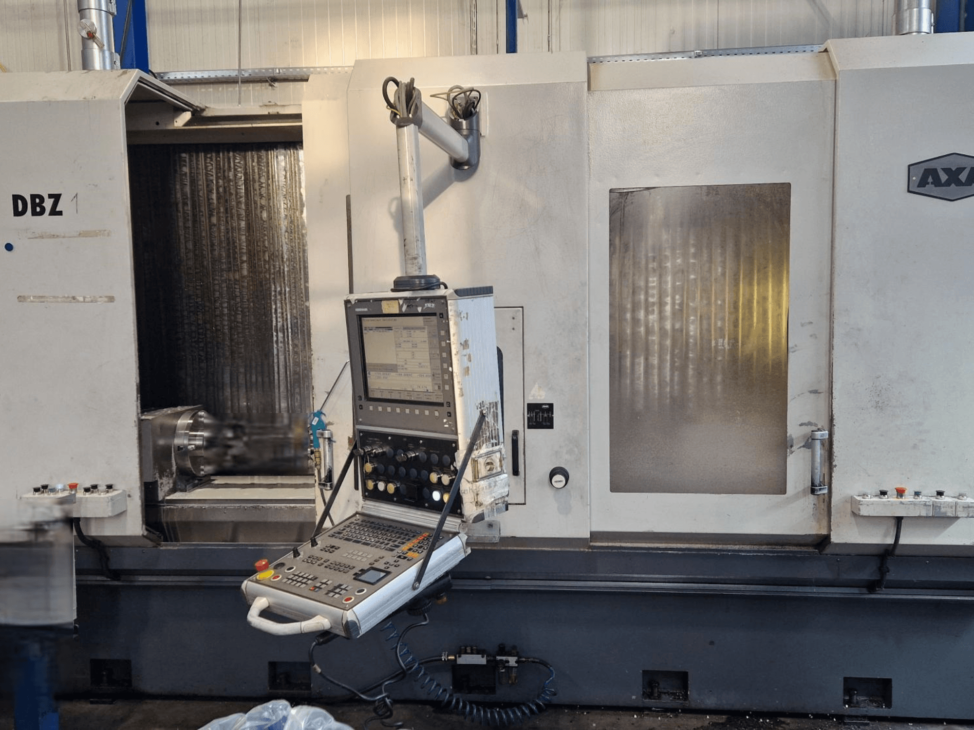 Vertikalni obradni centar AXA DBZ prikazan iz kutnog prednjeg pogleda, s upravljačkom pločom i vidljivim područjem alata za rezanje.