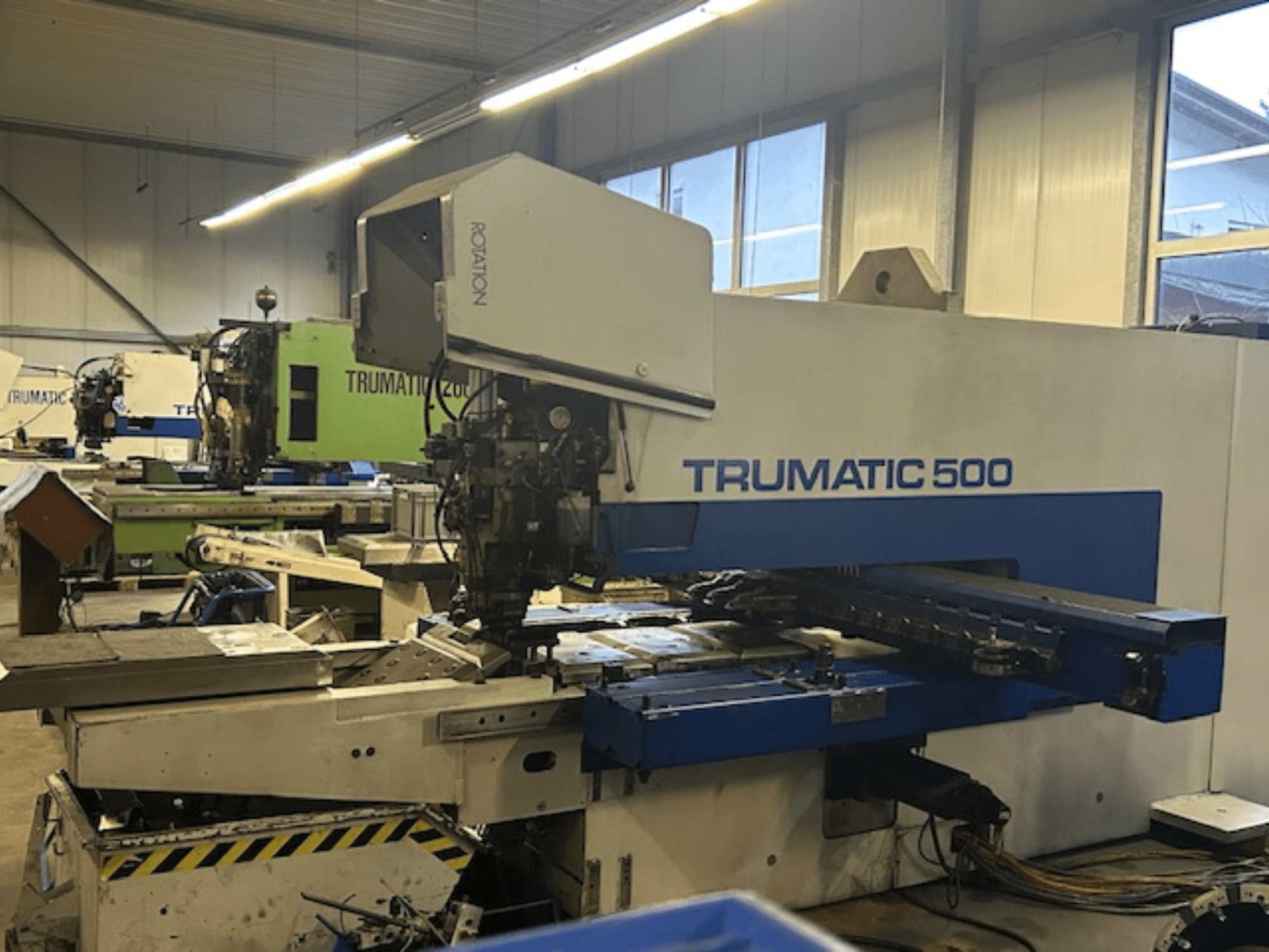 TRUMPF TRUMATIC 500 CNC stroj za probijanje, prednji pogled, s upravljačkom pločom i mehaničkim dijelovima. Industrijska radionica.