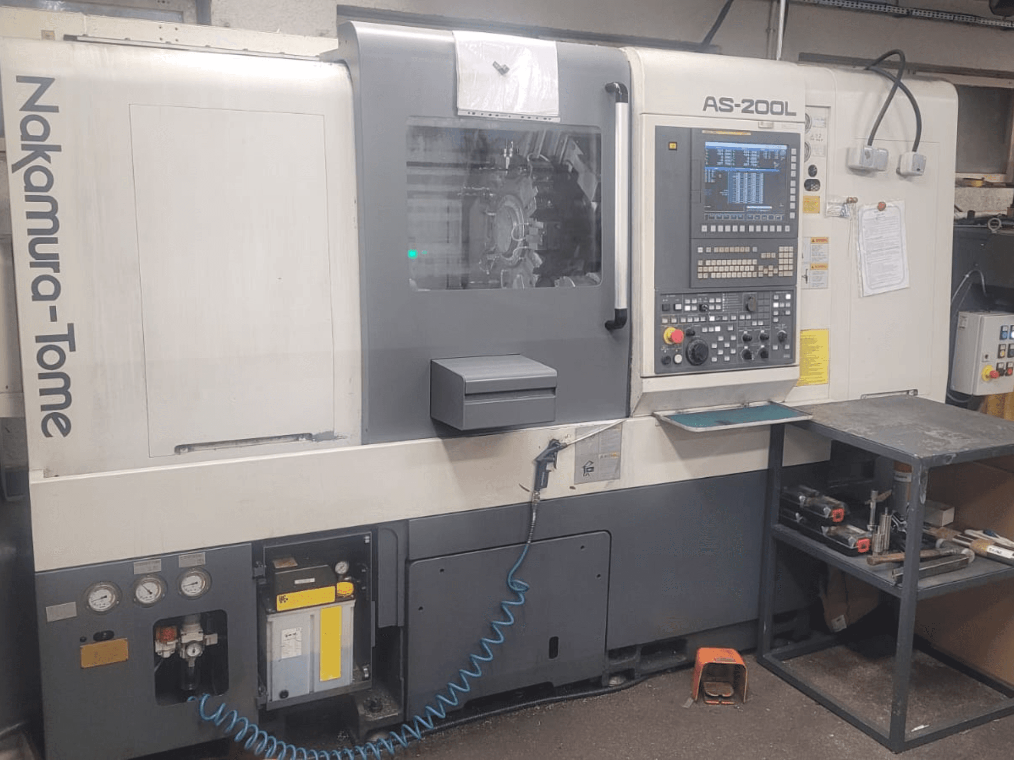 NAKAMURA-TOME AS-200L horizontalni tokarski stroj, prednji pogled s upravljačkom pločom, vretenom i značajkama stroja.