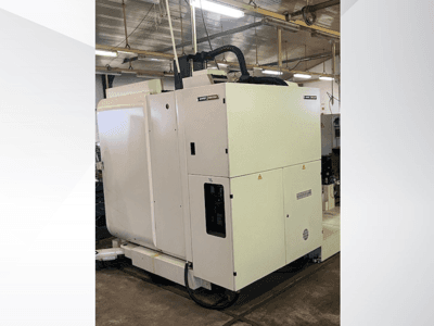 Bijeli industrijski CNC stroj gledan sprijeda, s upravljačkom pločom i ventilacijom, u radioničkom okruženju.