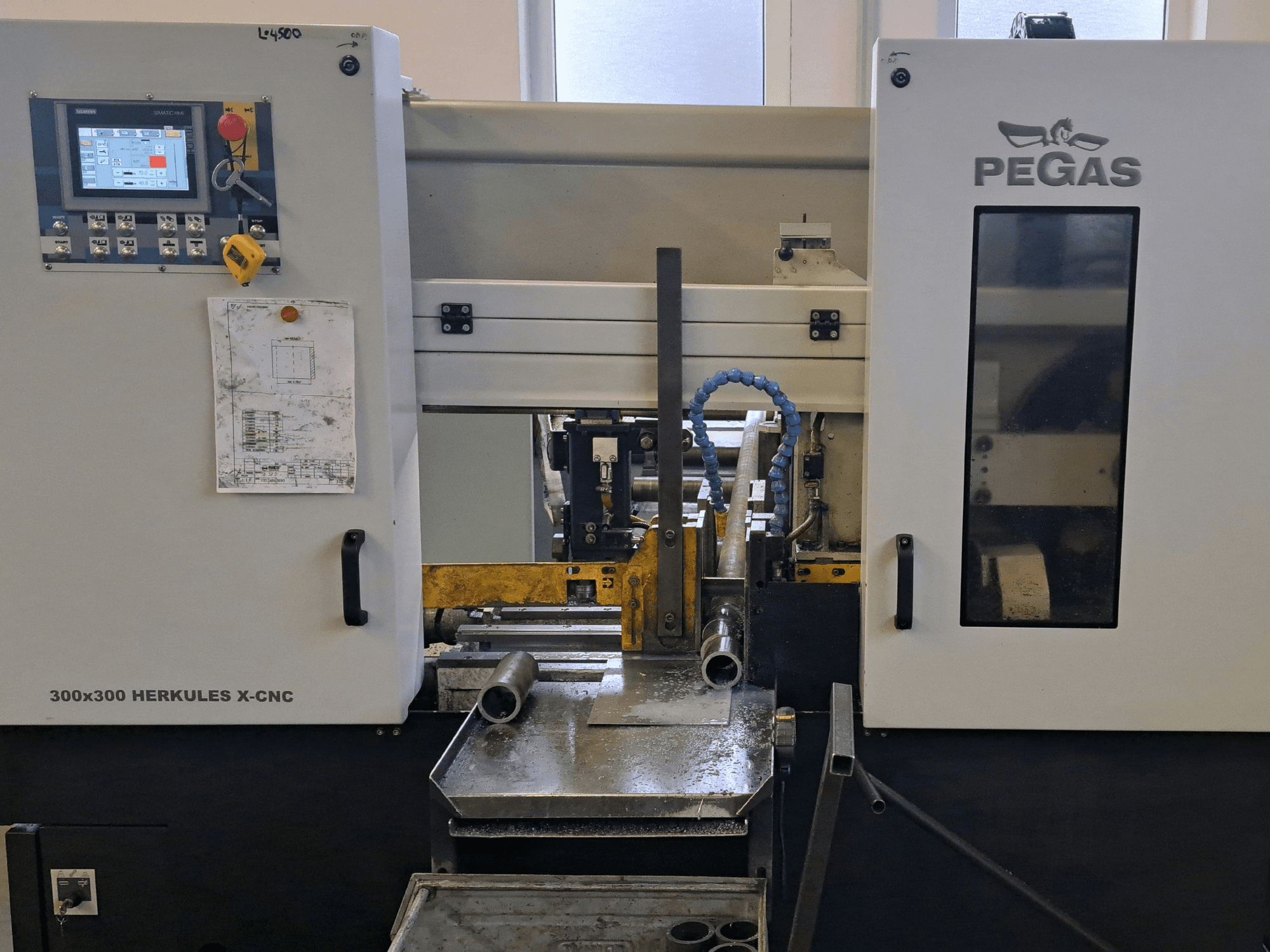 Pegas HERKULES X-CNC 300x300 stroj za obradu lima, prednji pogled, prikazuje upravljačku ploču i radno područje s metalnim dijelovima.