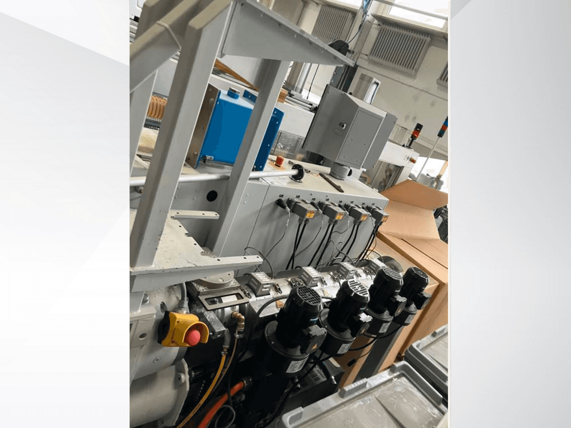 Upravljačka ploča industrijskih strojeva s više motora, mjerača i monitora; bočni pogled unutar tvorničkog okruženja.