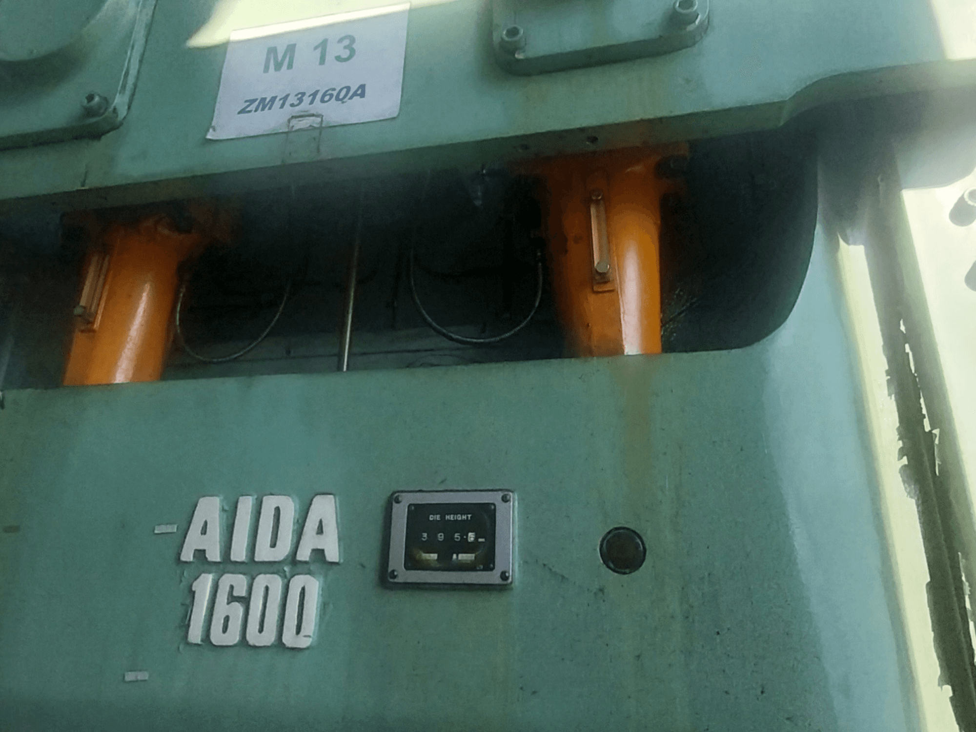 AIDA NC2-1600 mehanička preša za štancanje, pogled sprijeda; vidljive su narančaste hidraulične komponente i mjerač visine matrice.