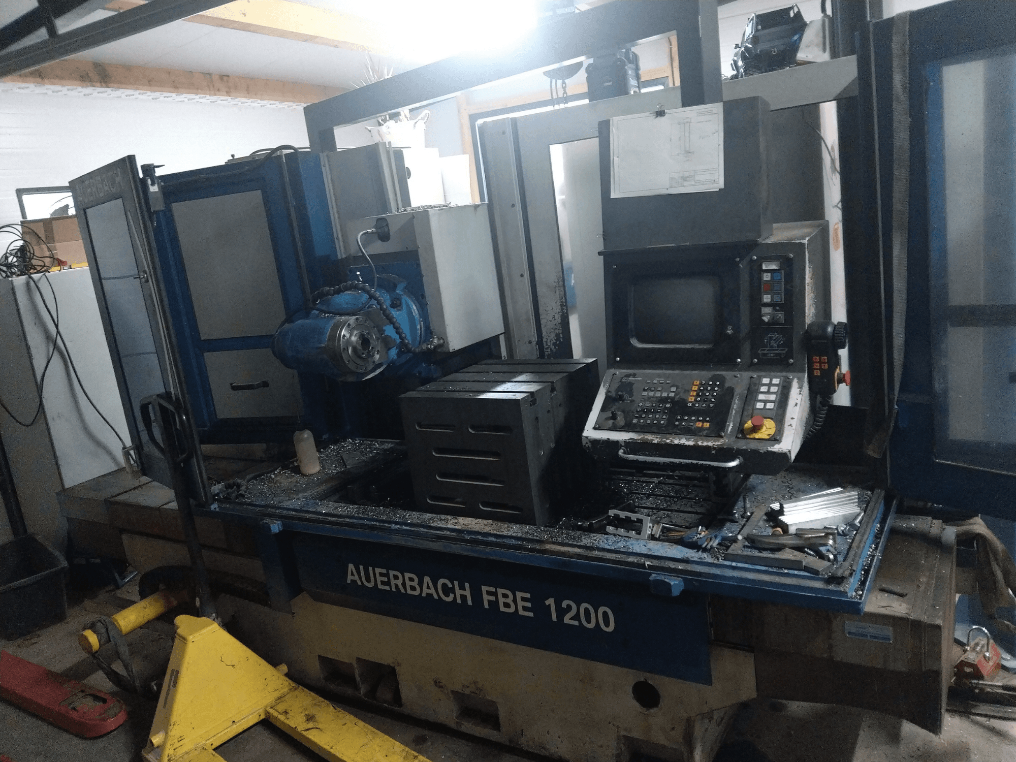 Bušilica za metal Auerbach FBE 1200, prednji pogled, prikazuje upravljačku ploču, motor i metalne strugotine na radnoj površini.