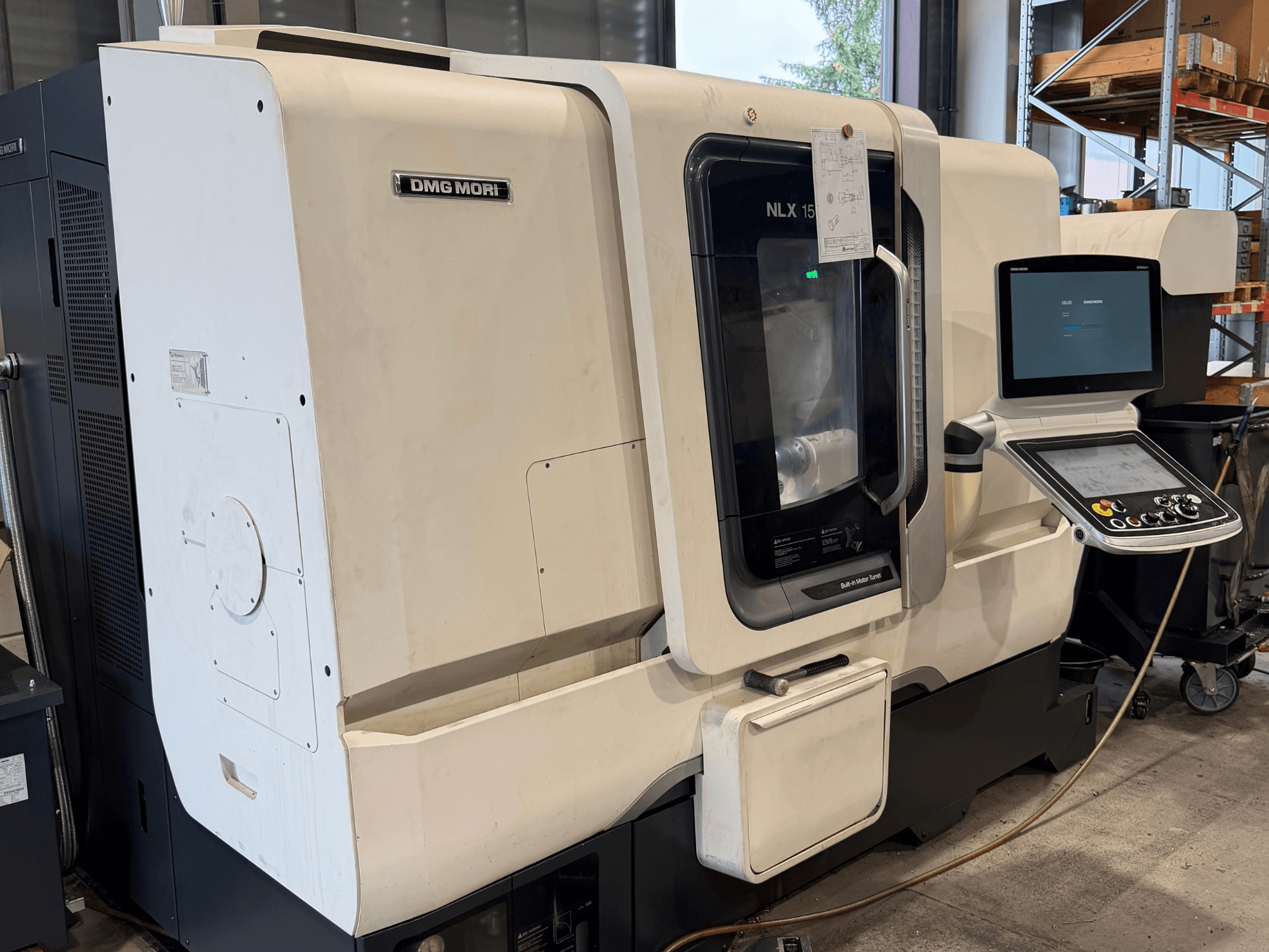 Prednji pogled na horizontalni tokarski stroj DMG MORI NLX1500MC/500, s prikazom upravljačke ploče i područja vretena kroz prozirni poklopac.