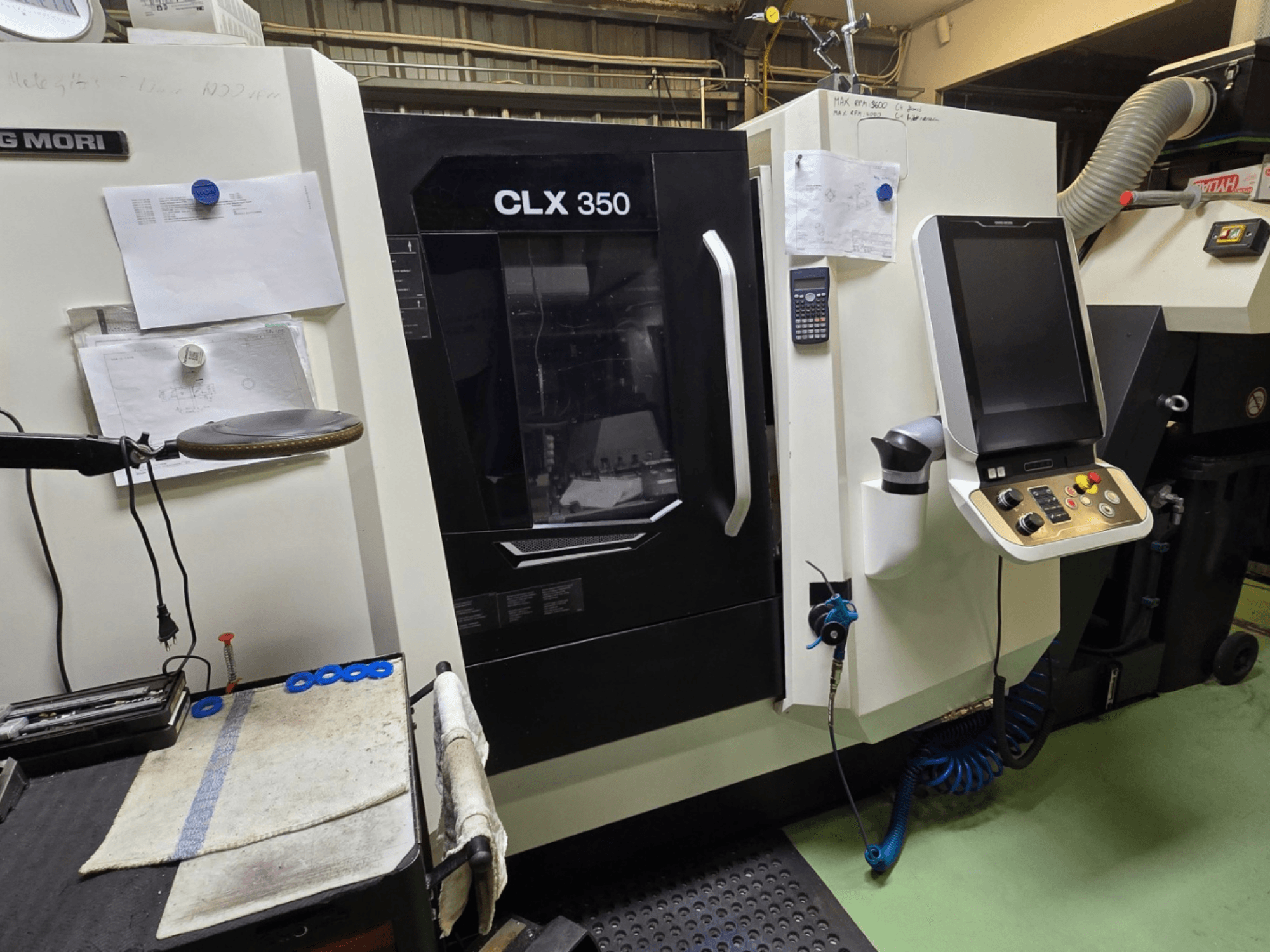 DMG MORI CLX 350 CNC tokarski stroj u radionici; prednji pogled s vidljivom upravljačkom pločom, alatima i radnim prostorom.