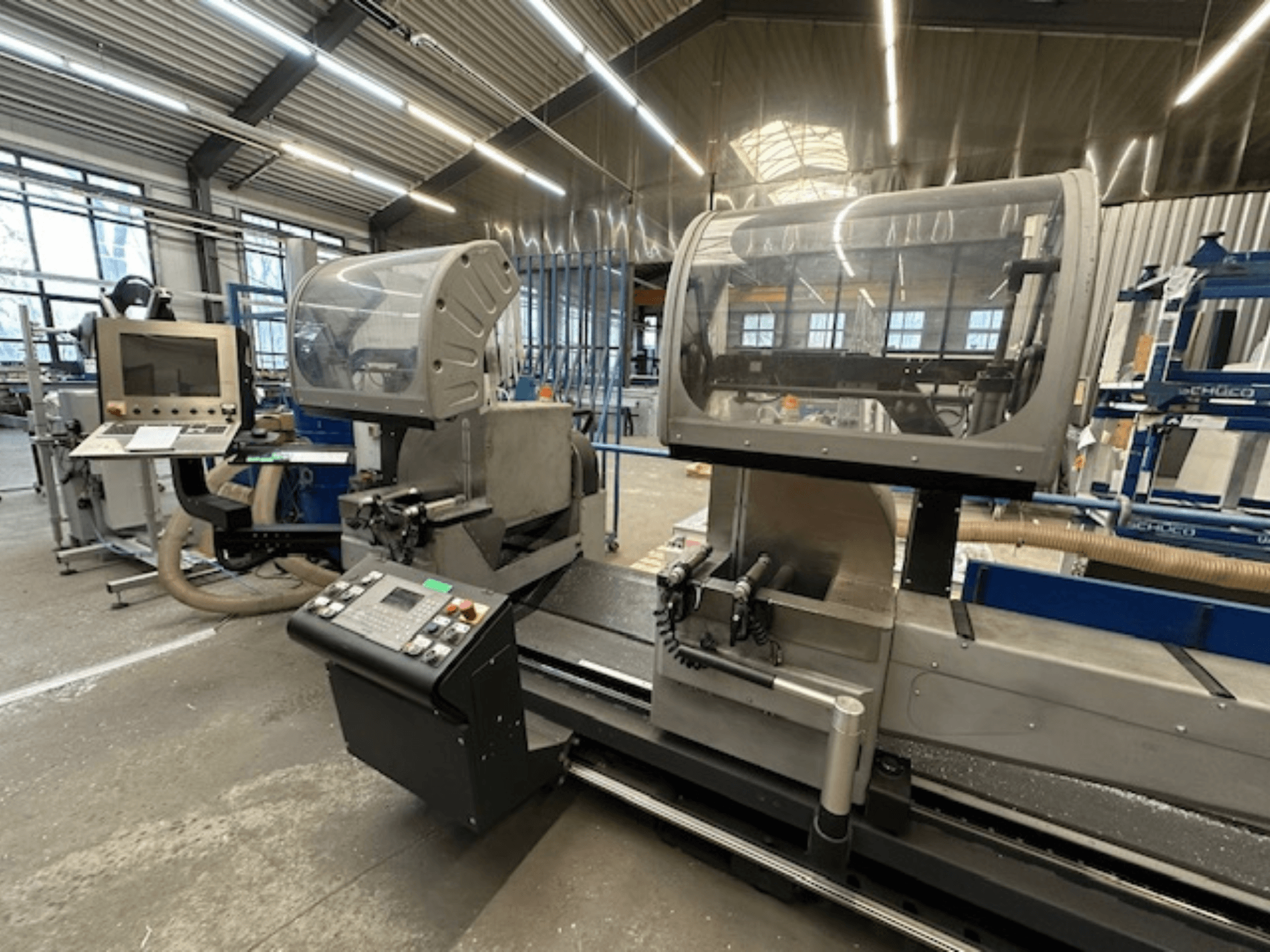 Kružna pila za metal SCHÜCO PDG E CUT, prednji pogled, s upravljačkom pločom, zaštitnim poklopcima i prostorom za rezanje u radioničkom okruženju.