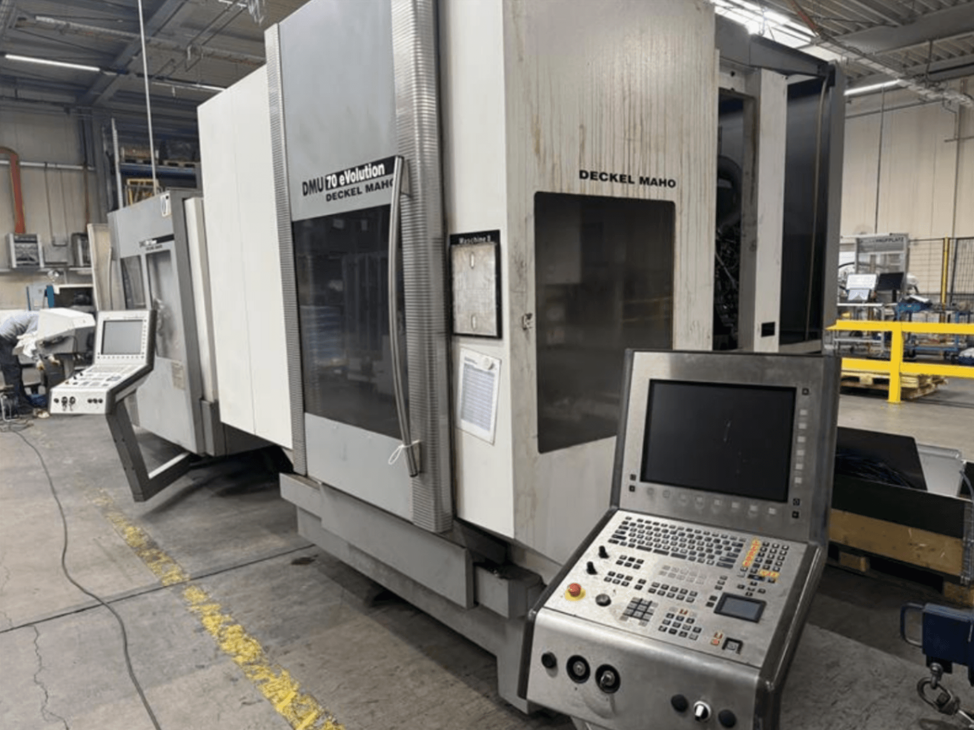 Prednji pogled na Deckel Maho DMU 70 eVOLUTION CNC stroj s upravljačkom pločom, smješten u proizvodnom pogonu.