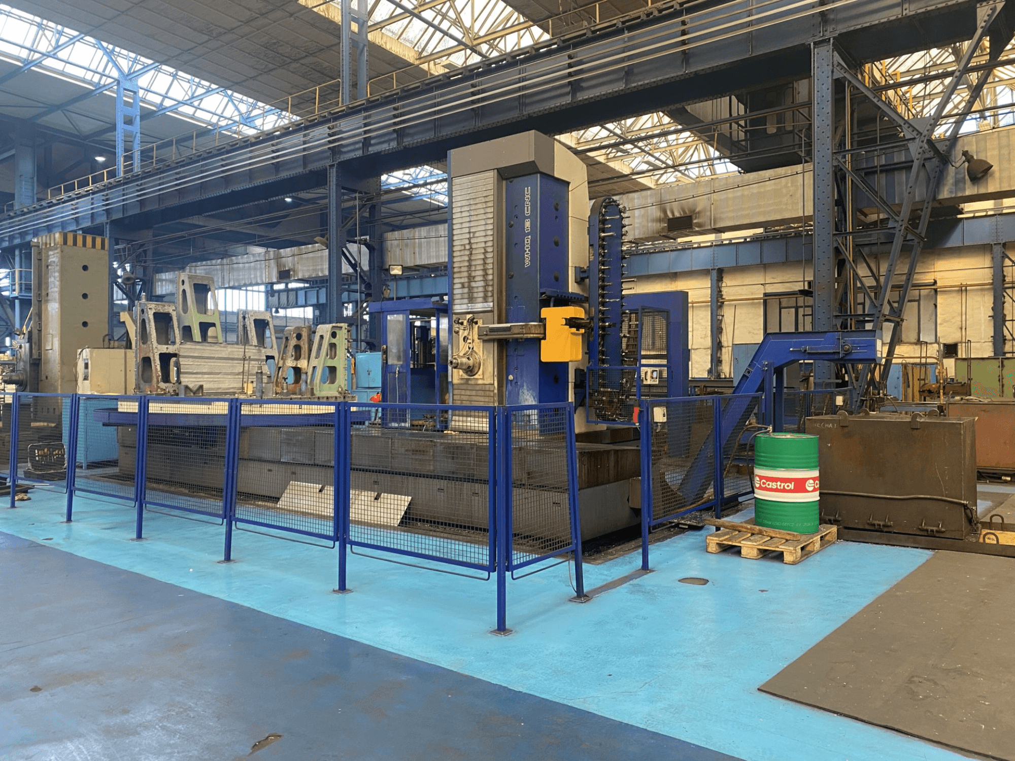 TOS WHQ 13 CNC bušilica u radionici, prednji pogled, s plavim okvirom i sigurnosnom ogradom oko nje.