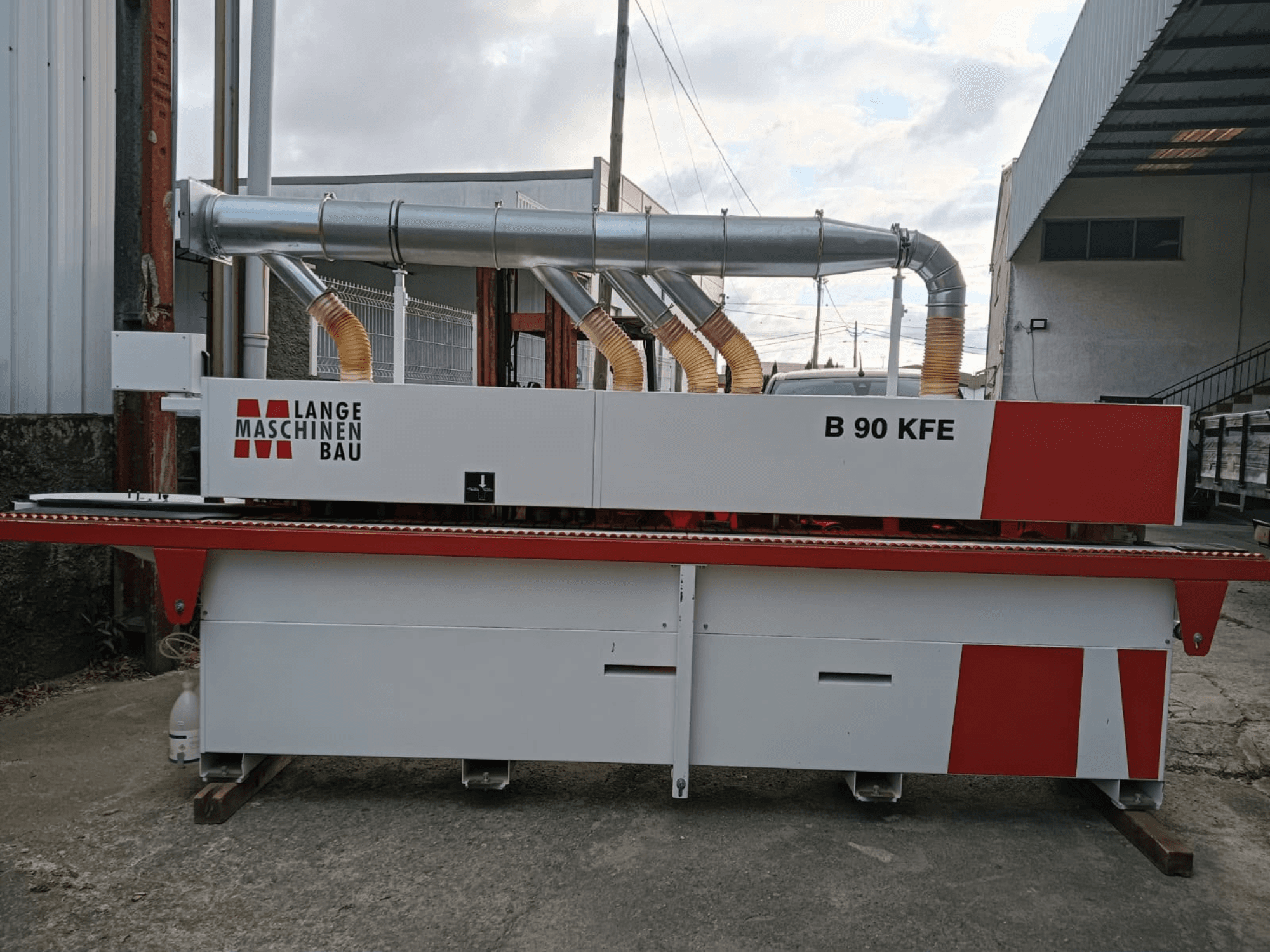 LANGE Maschinenbau B 90 KFE rubna traka u bočnom pogledu s dvostrukim ispušnim cijevima i crvenim detaljima, smještena u industrijskom radnom prostoru.