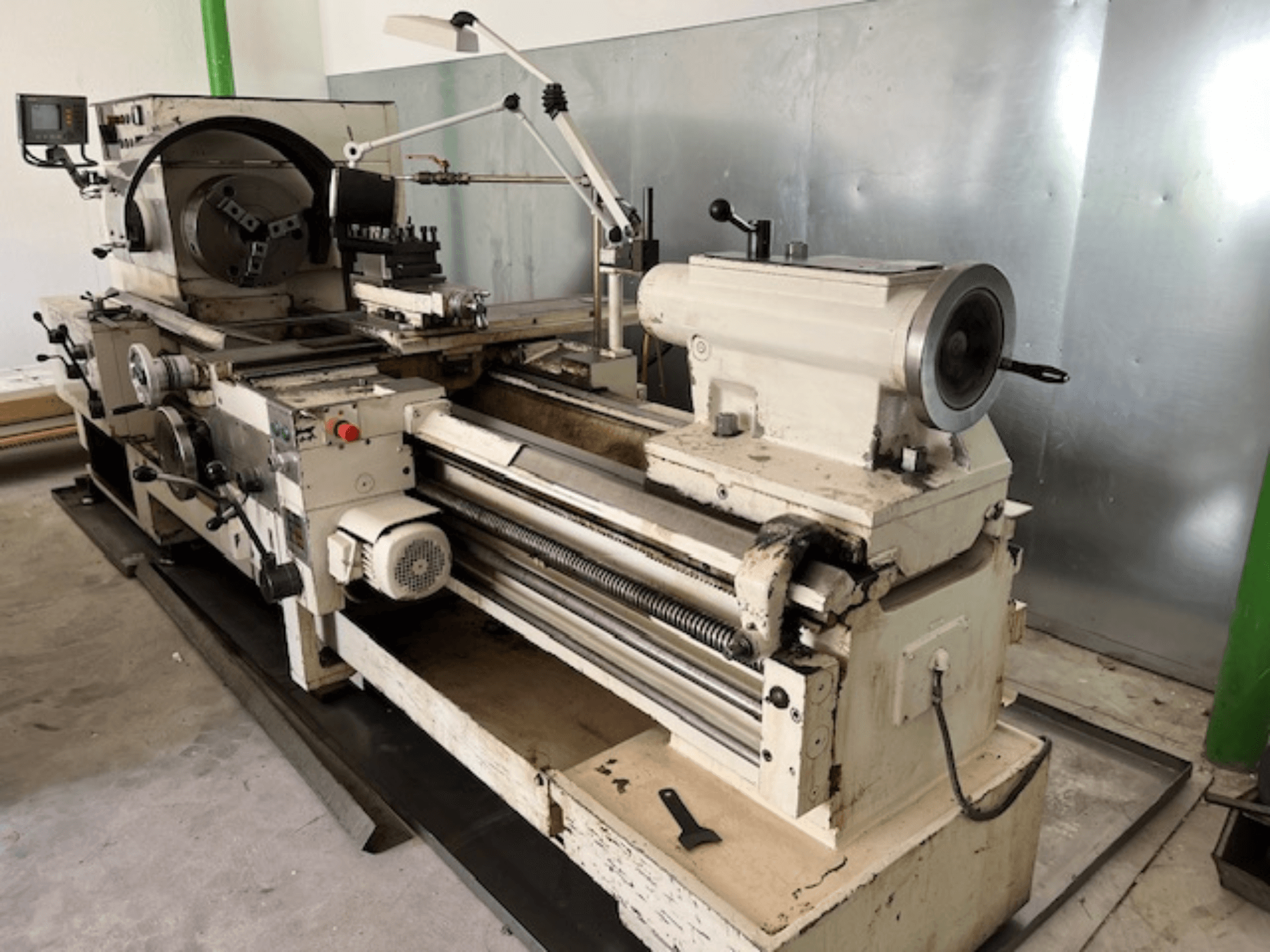 Starinski metalni tokarski stroj s upravljačkom pločom i alatima, bočni pogled, koji prikazuje operativne elemente i metalnu završnu obradu.