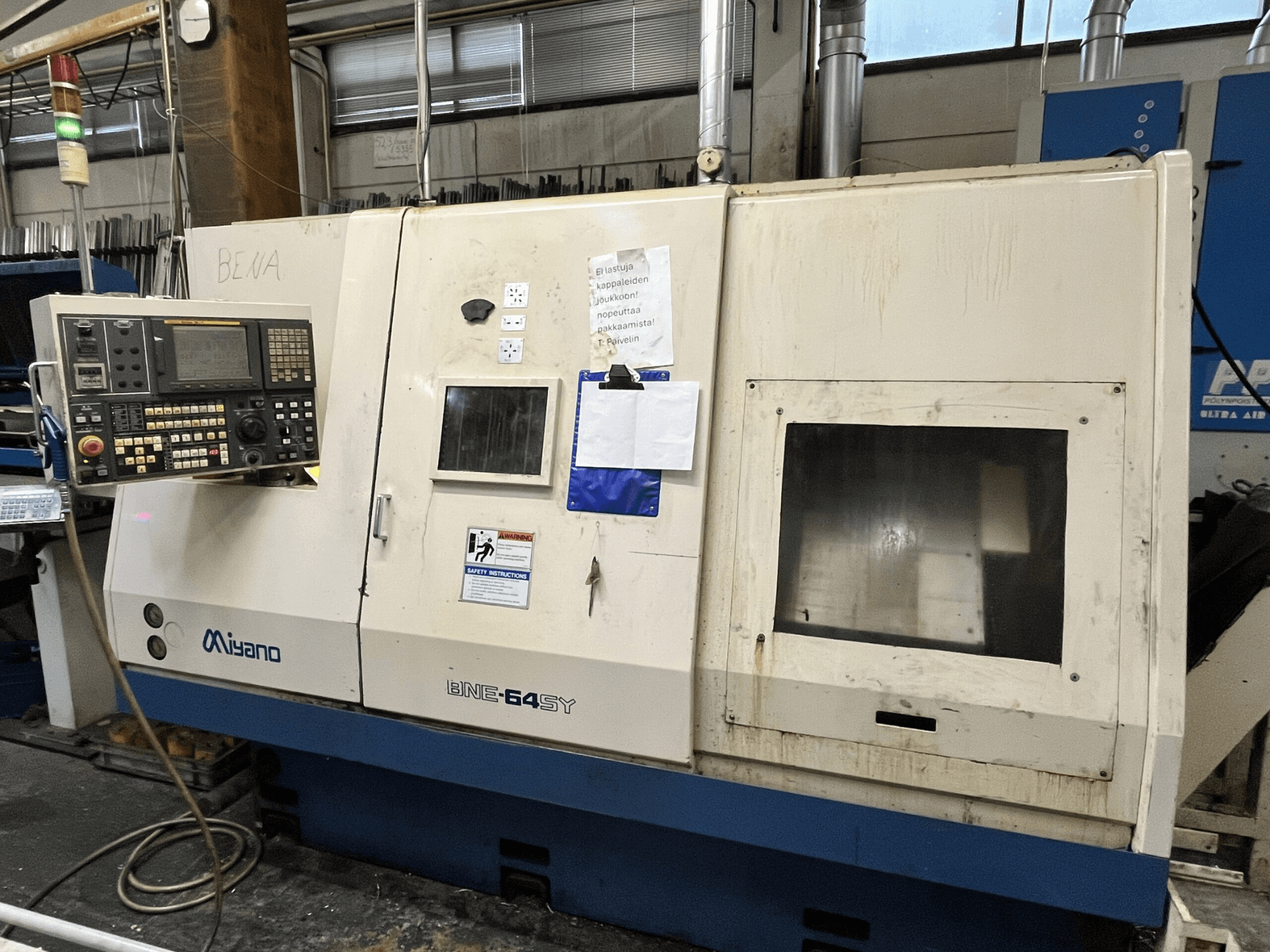 Miyano BNE-64SY CNC tokarski stroj, pogled sprijeda, ima upravljačku ploču s gumbima, LCD i naljepnice za održavanje na kućištu.