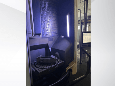 Vertikalni obradni centar DMG MORI DMU 65 MonoBlock, prednji pogled koji prikazuje rotacijski stol s obratkom i upravljačku ploču.