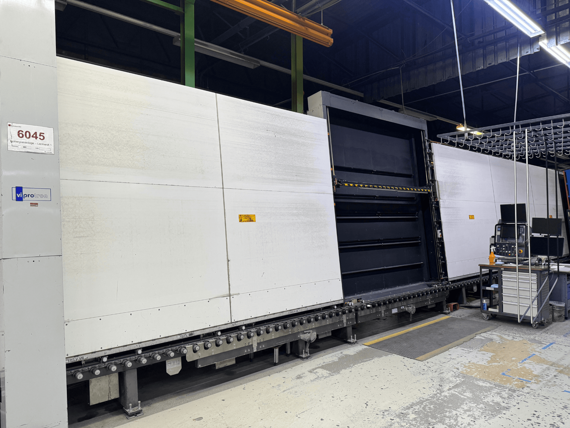 Prednji pogled na Vipro stroj za izradu kalupa s otvorenom pločom, na kojoj je prikazana operativna oprema i radni prostor pored nje. Model 6045.