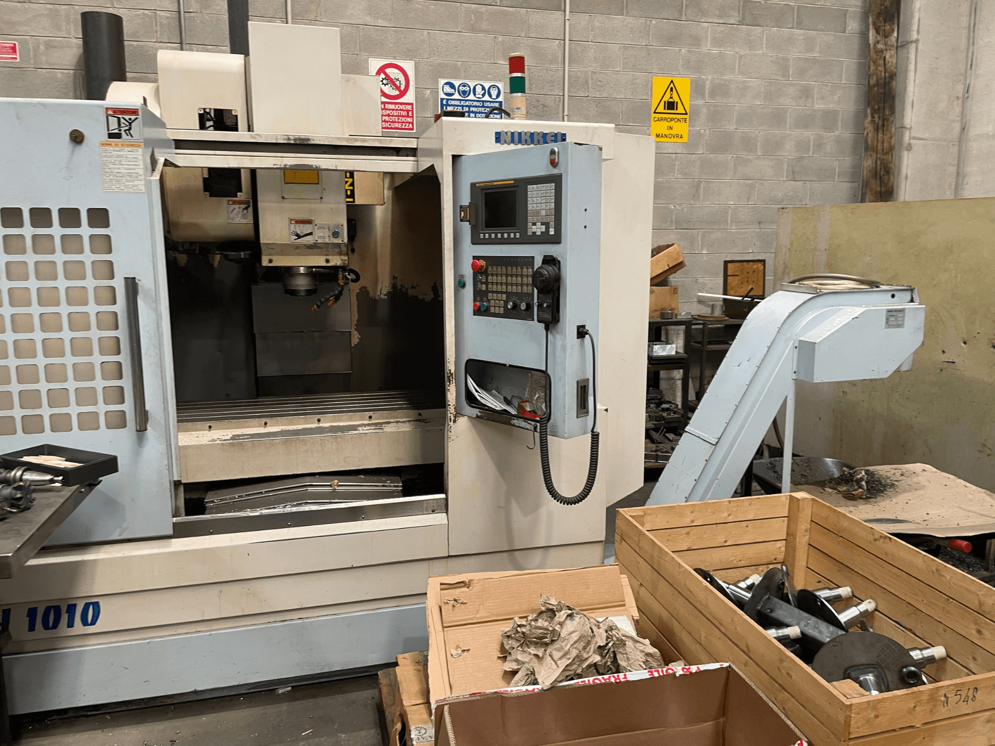 Vertikalni obradni centar tvrtke Other, model VH-1010, pogled sprijeda s vidljivim upravljačkim elementima i kutijama u blizini.