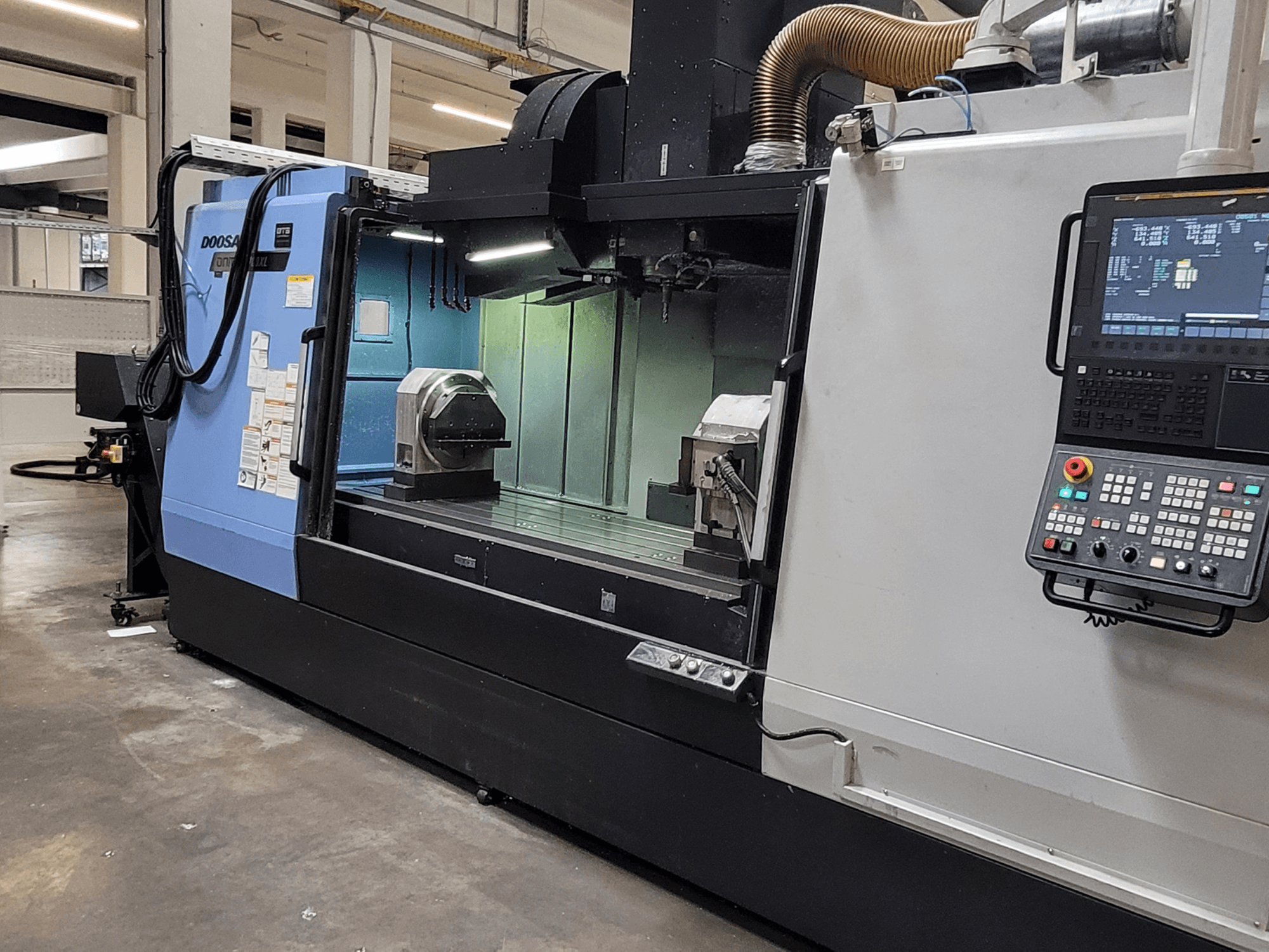 Vertikalni obradni centar DOOSAN DNM 6700 XL, prednji pogled s upravljačkom pločom, radnim stolom i područjem obrade.