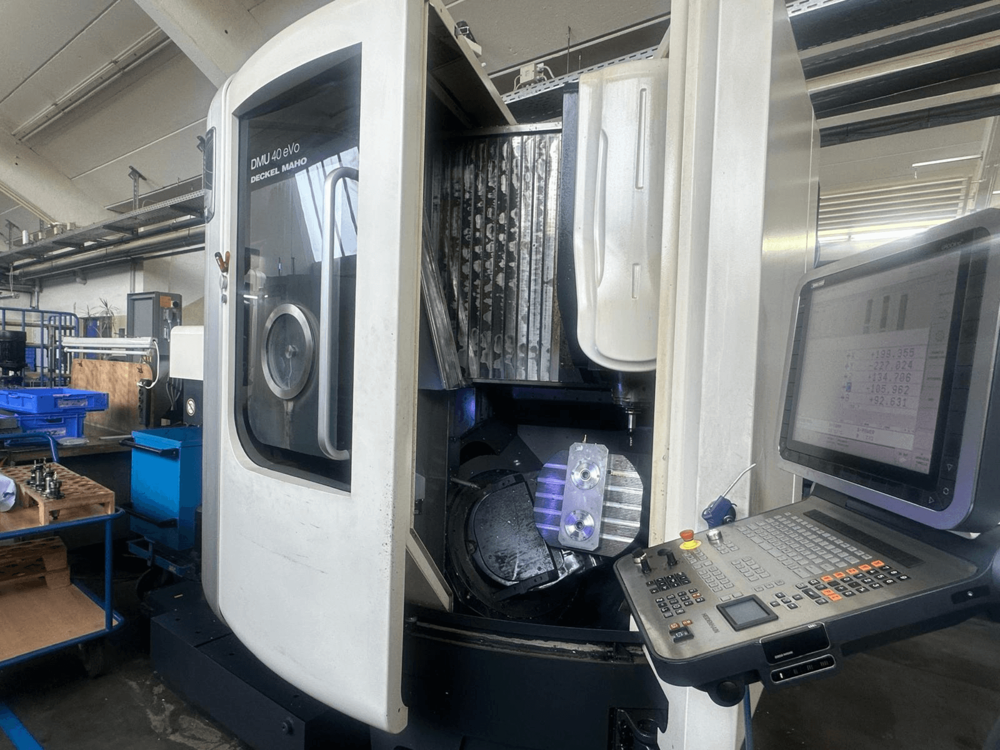 Glodalica DMU 40 eVo tvrtke Deckel Maho u radionici, prednji pogled, prikazuje upravljačku ploču i metalni dio u vretenu.