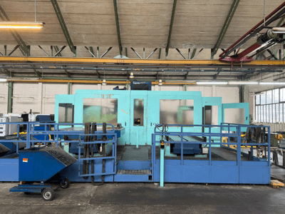 Industrijski plavi CNC stroj sa zaštitnim pločama, prednji pogled, s prostorom za pohranu alata i kolicima za sakupljanje otpada sa strane.