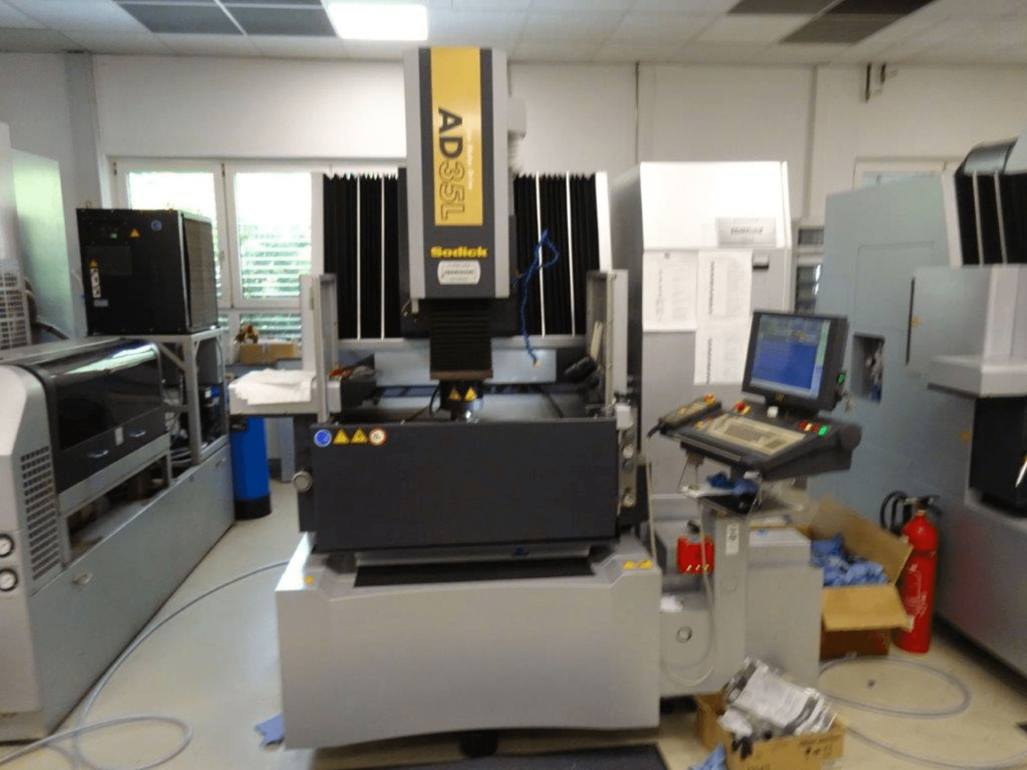 Sodick AD35L CNC stroj s prednje strane, s upravljačkom pločom, rashladnom jedinicom i sigurnosnim indikatorima.