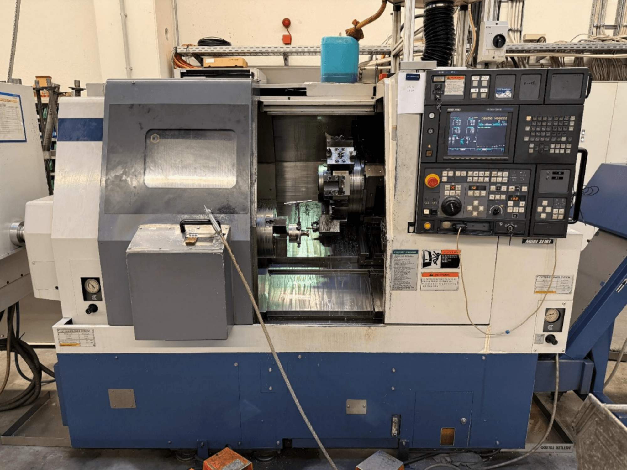 MORI SEIKI SL-250ASMC Tokarsko-glodački centar, prednji pogled koji prikazuje upravljačku ploču i steznu glavu obratka u radu.