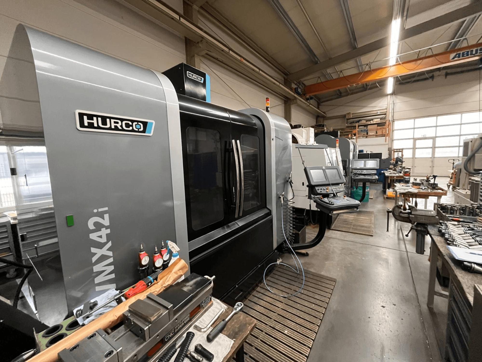 Hurco VMX42i CNC stroj u radionici, prednji pogled. Ima upravljačku ploču, sivo kućište i industrijsko okruženje.
