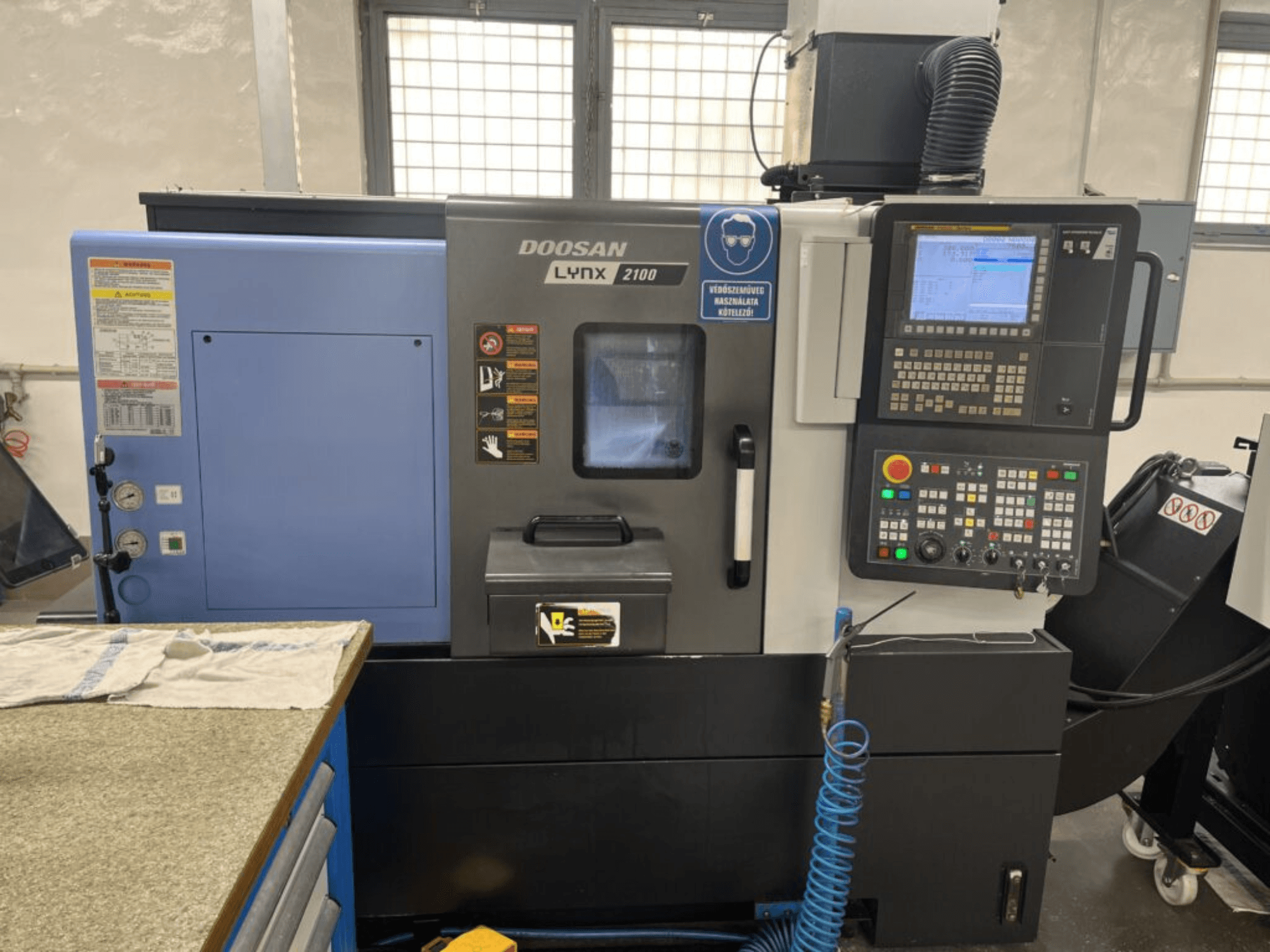 Horizontalni tokarski stroj DOOSAN Lynx 2100A, prednji pogled s prikazom upravljačke ploče, sučelja operatera i značajki stroja.
