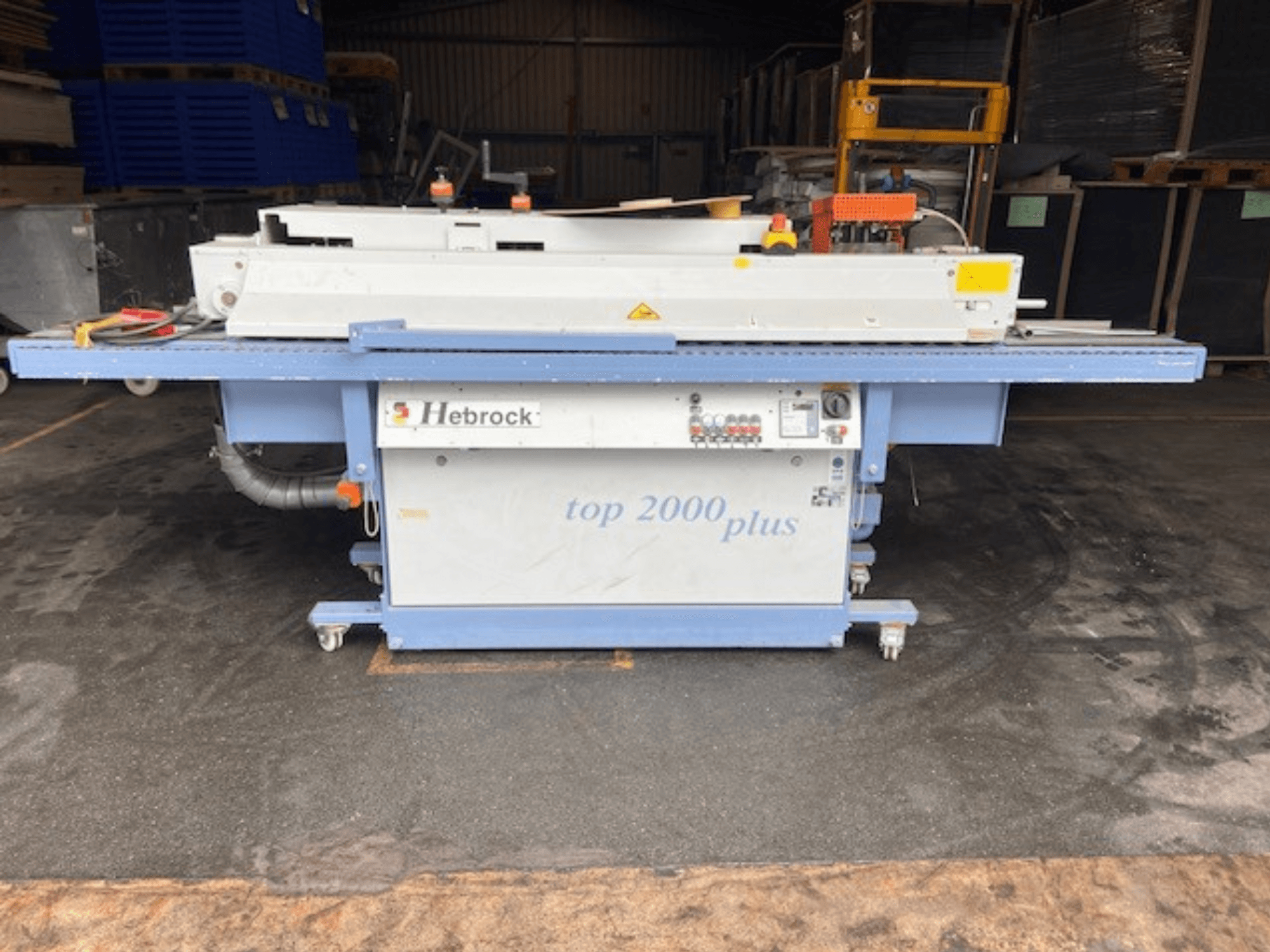 Hebrock Top 2000 Plus, prednji pogled; industrijski električni stroj s upravljačkom pločom, kotačima za mobilnost i vidljivim sigurnosnim naljepnicama.