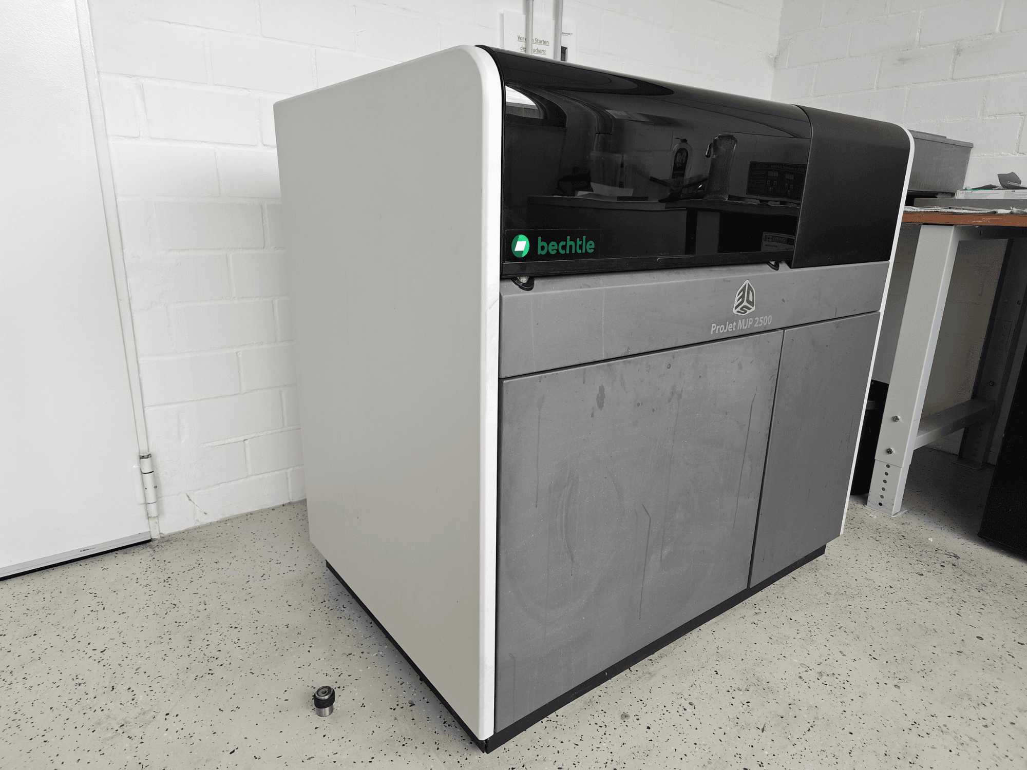 3D Systems ProJet MJP 2500 Plus plastični printer u prednjem pogledu; ima elegantan dizajn s tamnim vrhom i svijetlim tijelom.