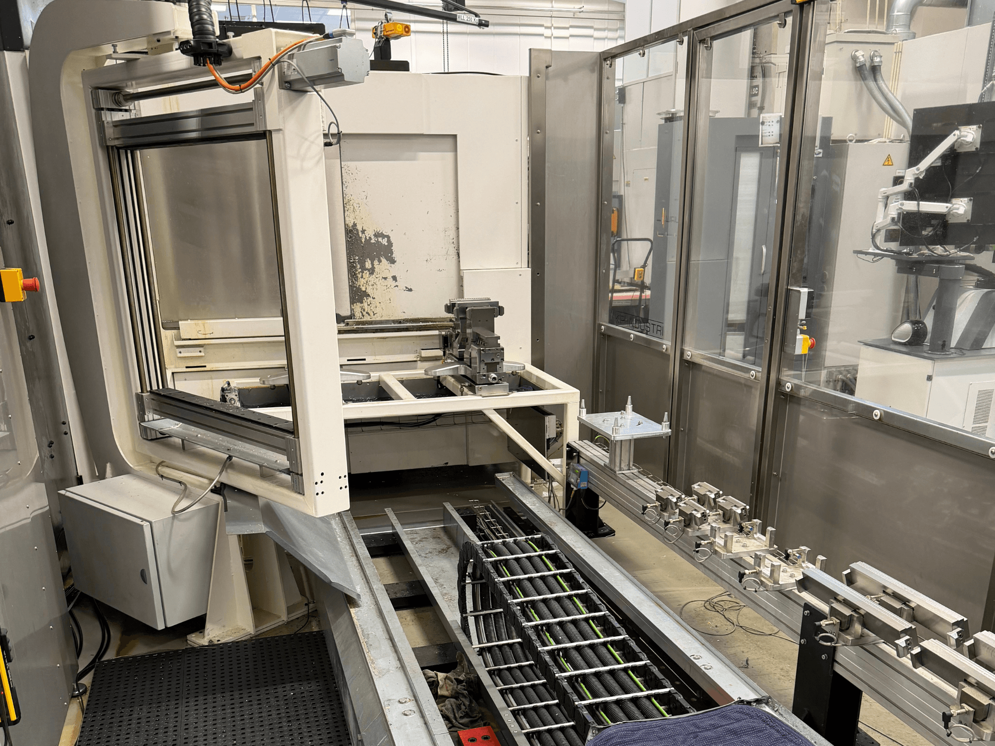 Automatizirana industrijska radna stanica s bočnom slikom robotske ruke, sustava tračnica i upravljačke ploče.