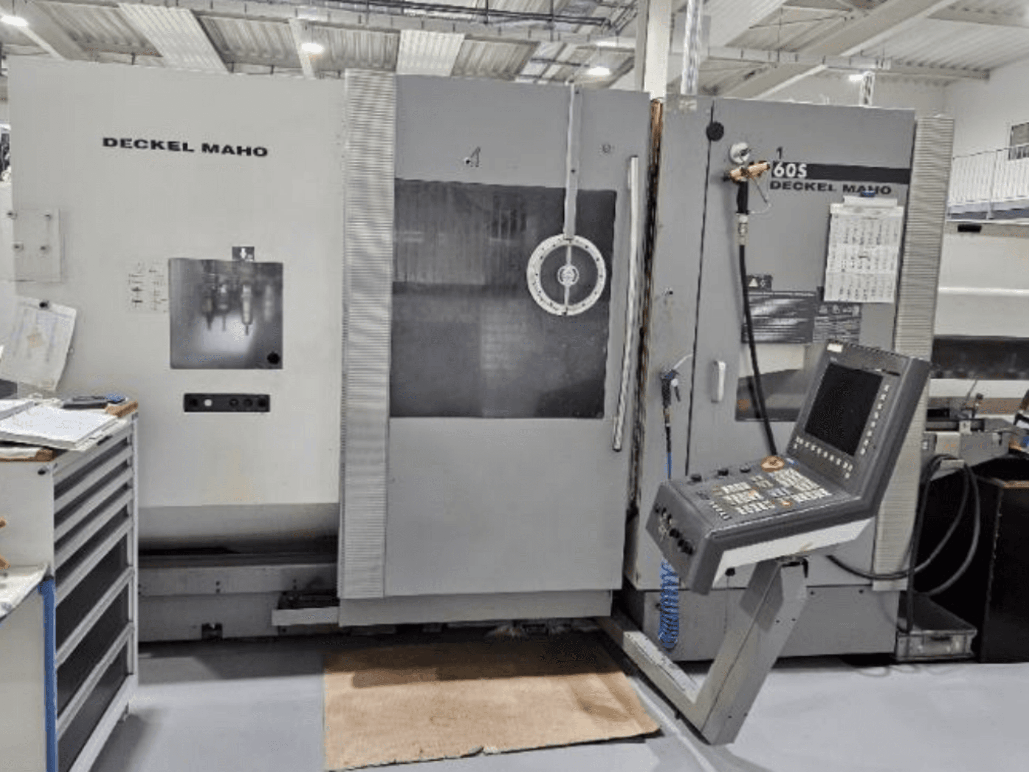 Prednji pogled na DECKEL MAHO 60S CNC stroj s upravljačkom pločom, vidljivi alati, u radioničkom okruženju.