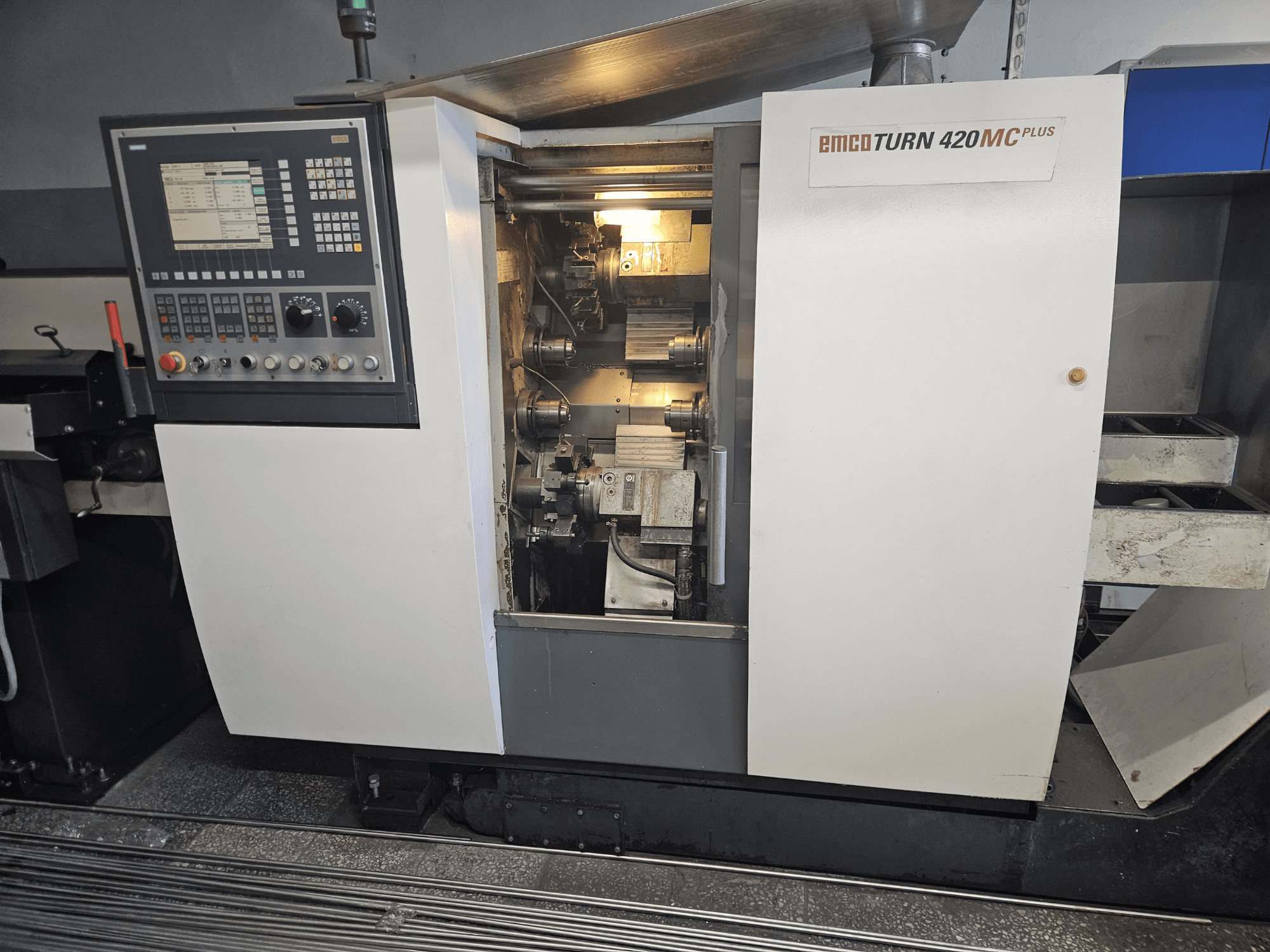 Viševretenski stroj EMCO TURN 420 MC Plus, prednji pogled s upravljačkom pločom i unutarnjim komponentama.
