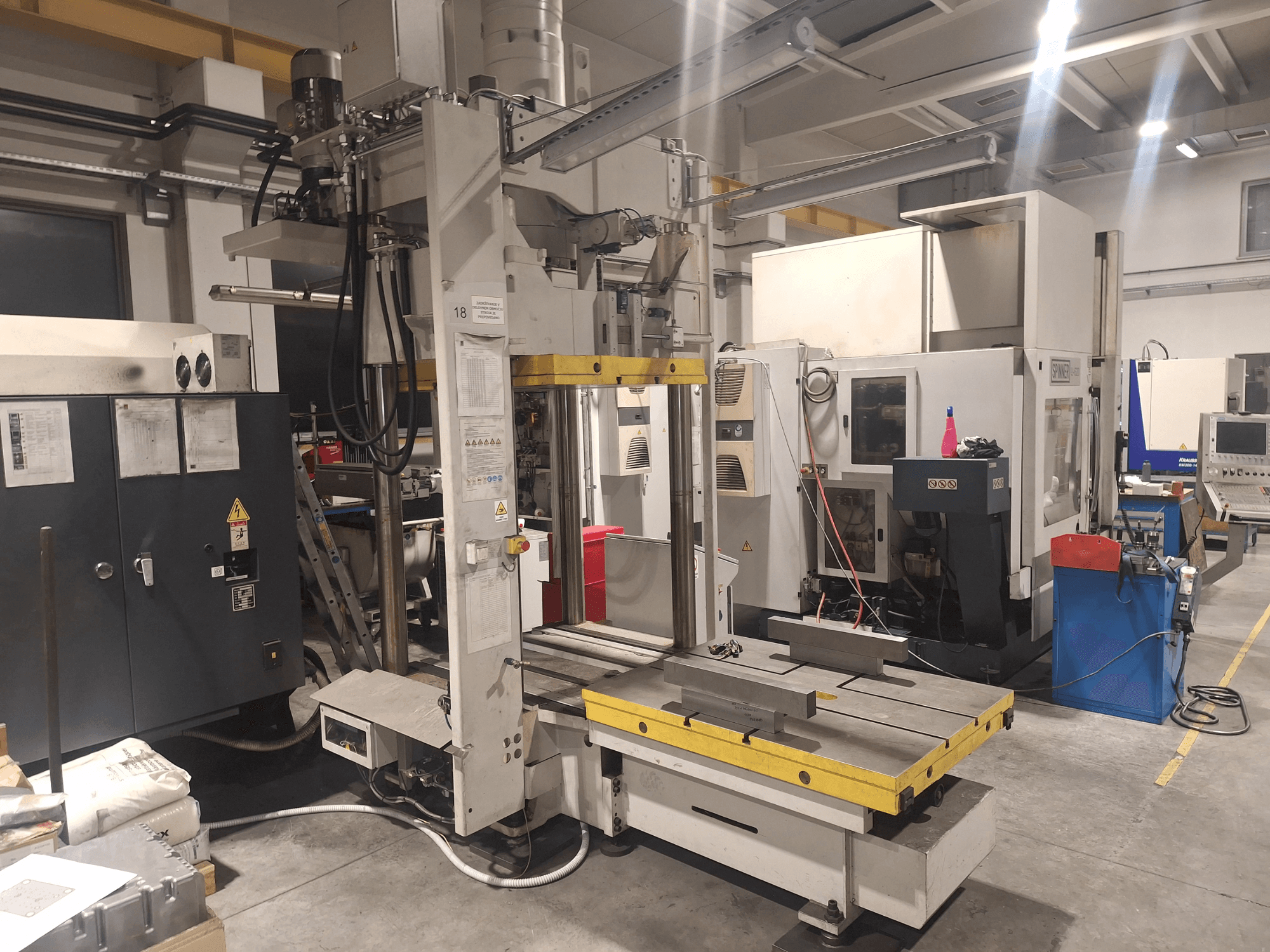 Horizontalna glodalica tvrtke Synergic, prednji pogled; ima široki stol i razne upravljačke ploče, u radioničkom okruženju.