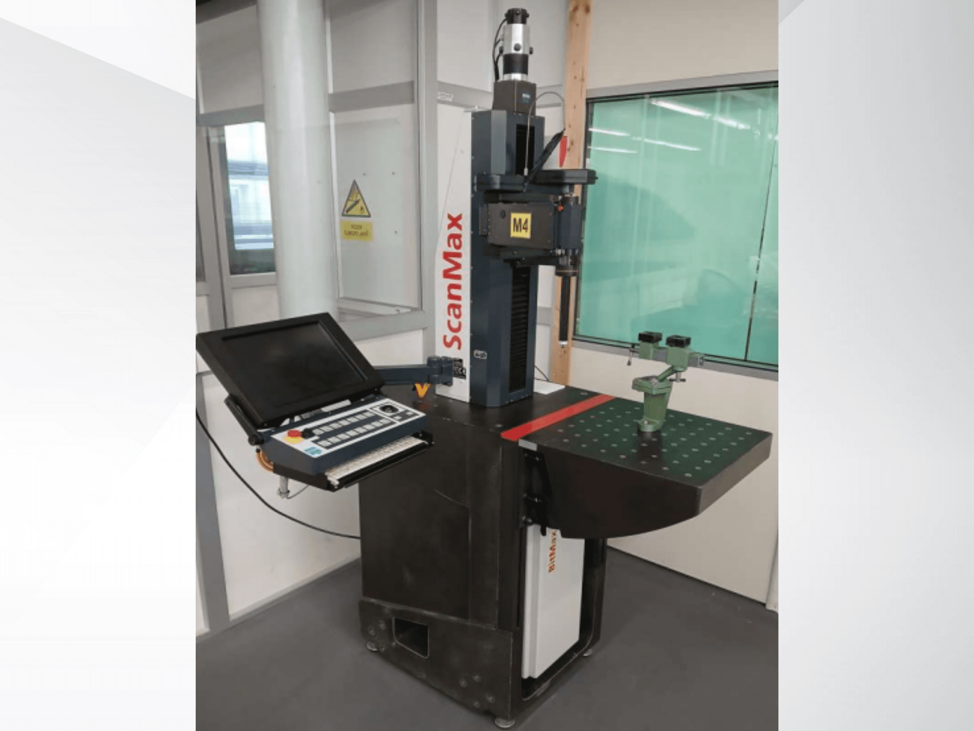 Mjerni stroj ScanMax M4, prednji pogled s upravljačkom pločom i zelenim kalibracijskim uređajem na točkastom radnom stolu.