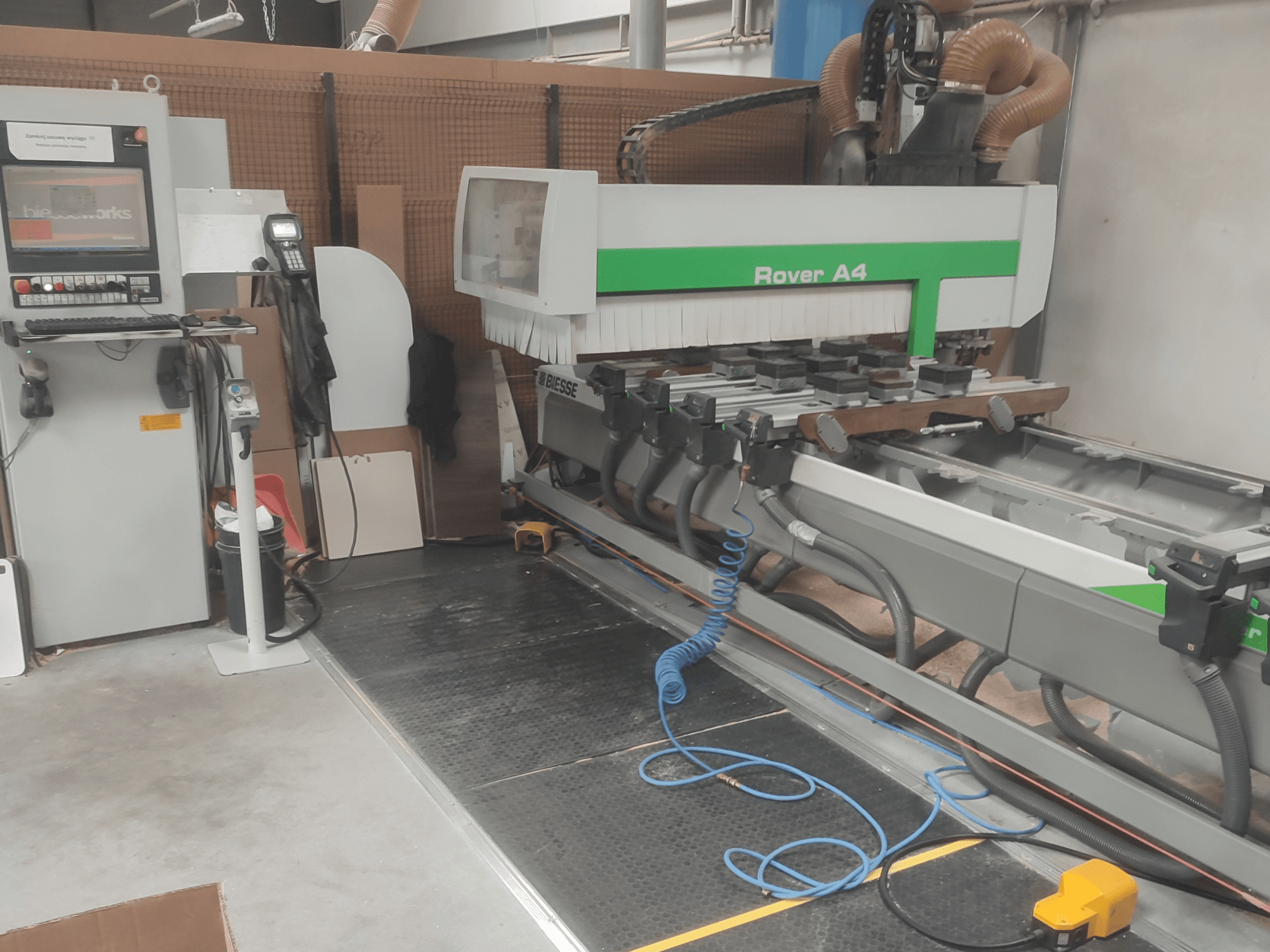 Bočni pogled na CNC centar za obradu drva BIESSE Rover A4, s prikazom upravljačke ploče, usisnih uređaja i sustava za usisavanje prašine.