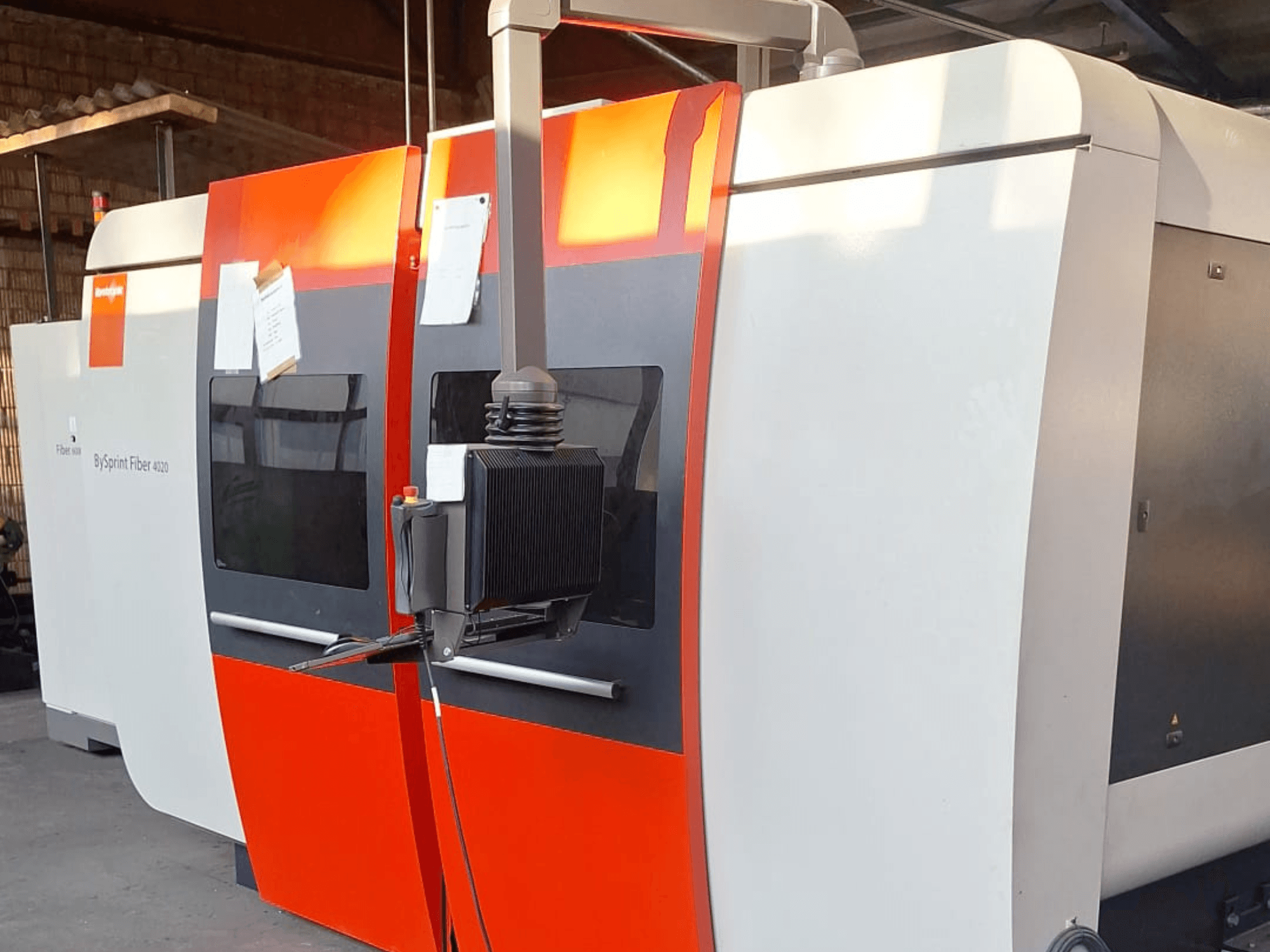 Stroj za lasersko rezanje BySprint Fiber 4020, bočni pogled, s crveno-bijelom vanjštinom, vidljiva je detaljna upravljačka ploča.