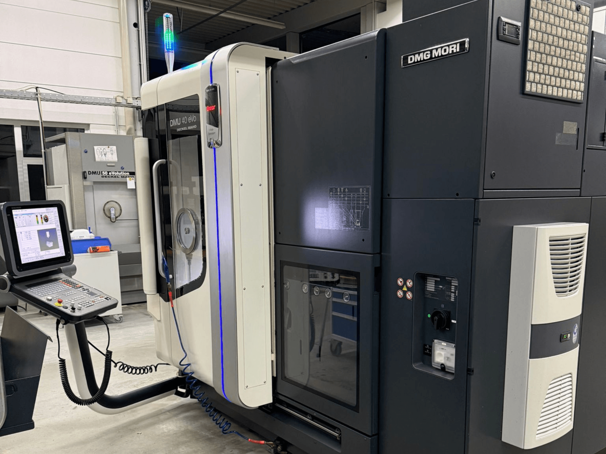 Stroj DMG MORI DMU 40 eVo, prednji pogled s prikazom kontrola, LED indikatora i elegantnog dizajna koji naglašava industrijske značajke.