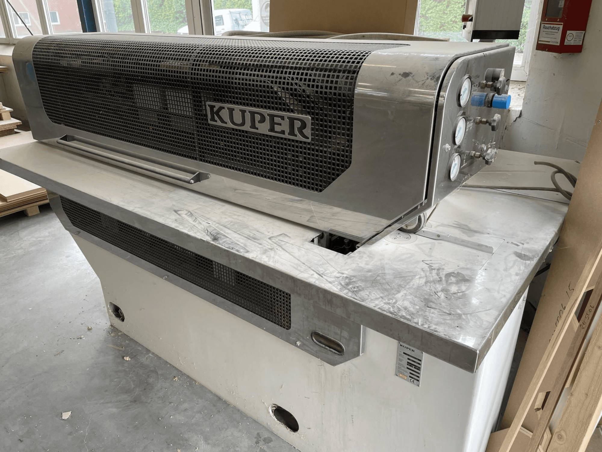 Giljotina za furnir KUPER FLI, prednji pogled, s tijelom od nehrđajućeg čelika, mjeračima i čistim područjem rezanja na radnom stolu.