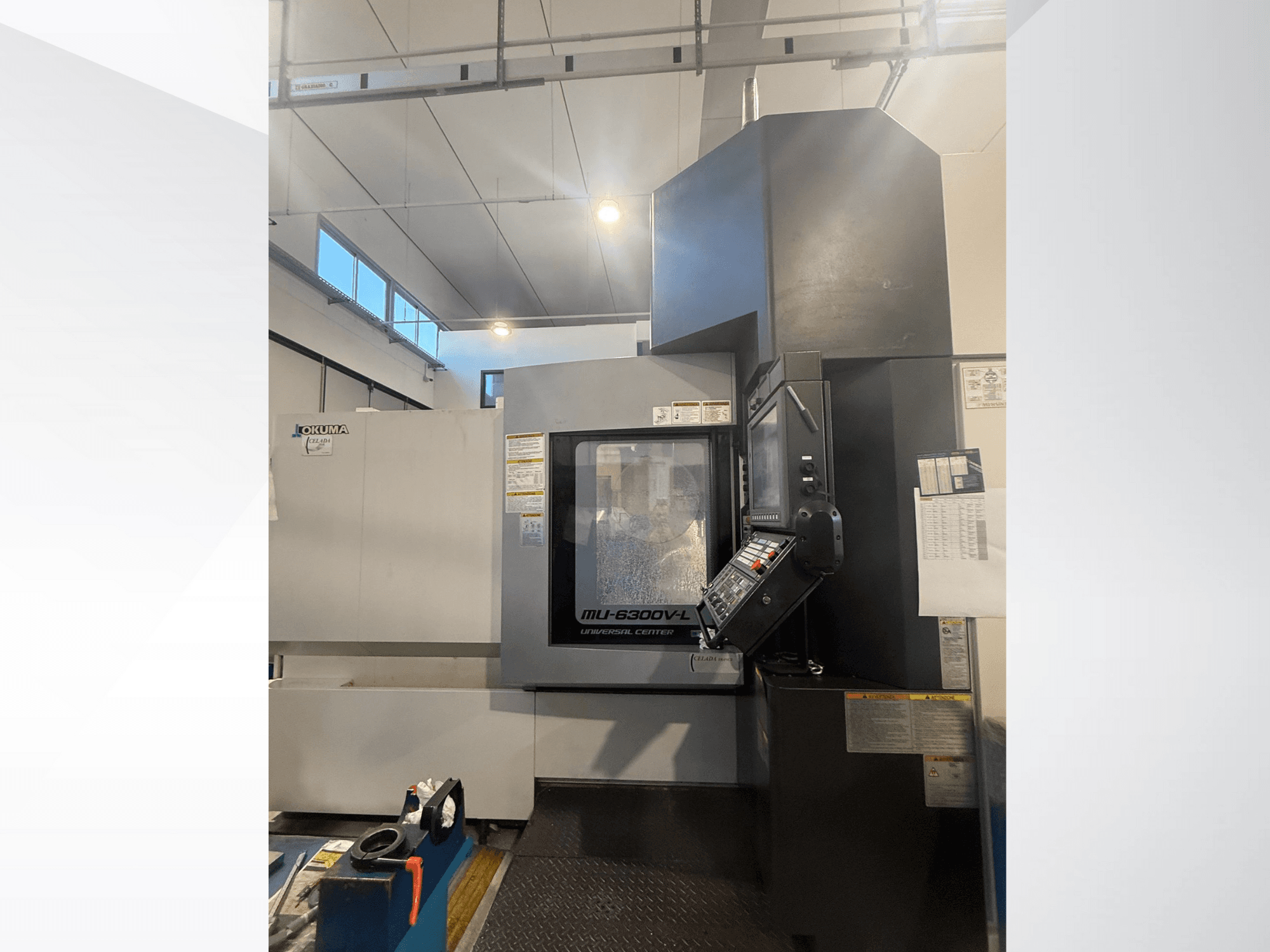 CNC stroj Okuma MU-6300V-L gledan sprijeda, s upravljačkom pločom i sigurnosnim naljepnicama.