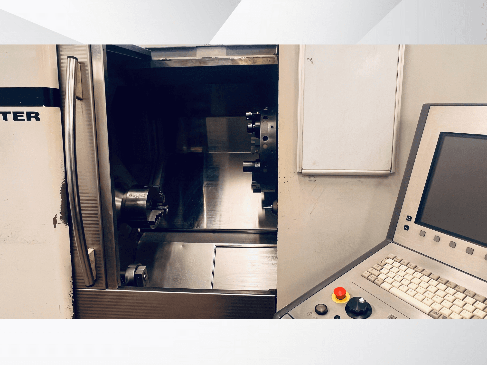 Prednji pogled na CNC stroj koji prikazuje otvorenu komoru i upravljačku ploču s tipkovnicom i tipkom za zaustavljanje u nuždi.