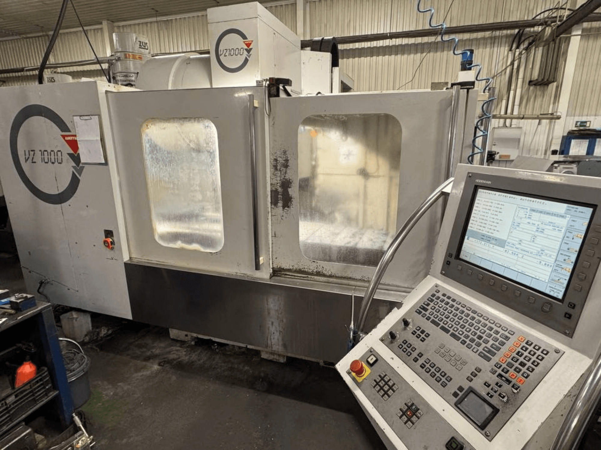 Prednji pogled na vertikalni obradni centar WEMAS VZ 1000, s upravljačkom pločom i prozirnim pristupnim vratima.