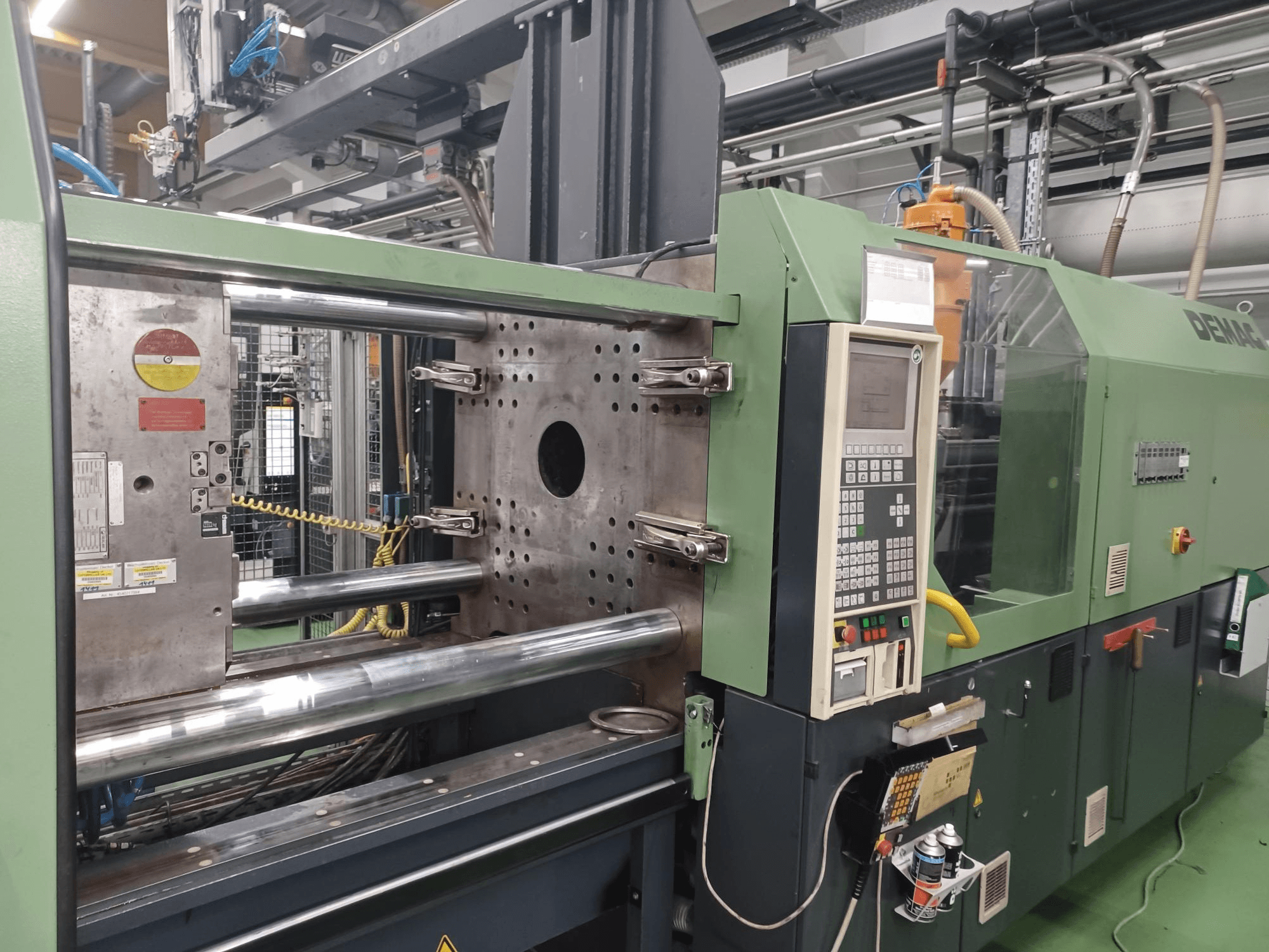 Demag stroj za brizganje plastike, prednji pogled, s upravljačkom pločom, metalnim hidrauličkim cilindrima i sigurnosnim značajkama.
