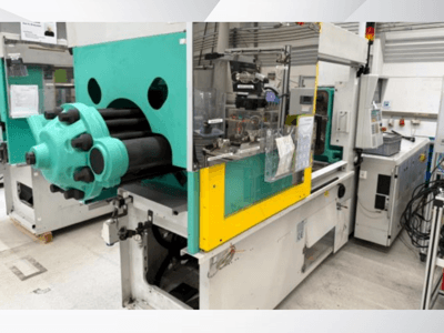 Stroj za brizganje plastike, svijetloplava i žuta, prednji pogled, s vidljivim kalupom i upravljačkom pločom s naljepnicama.