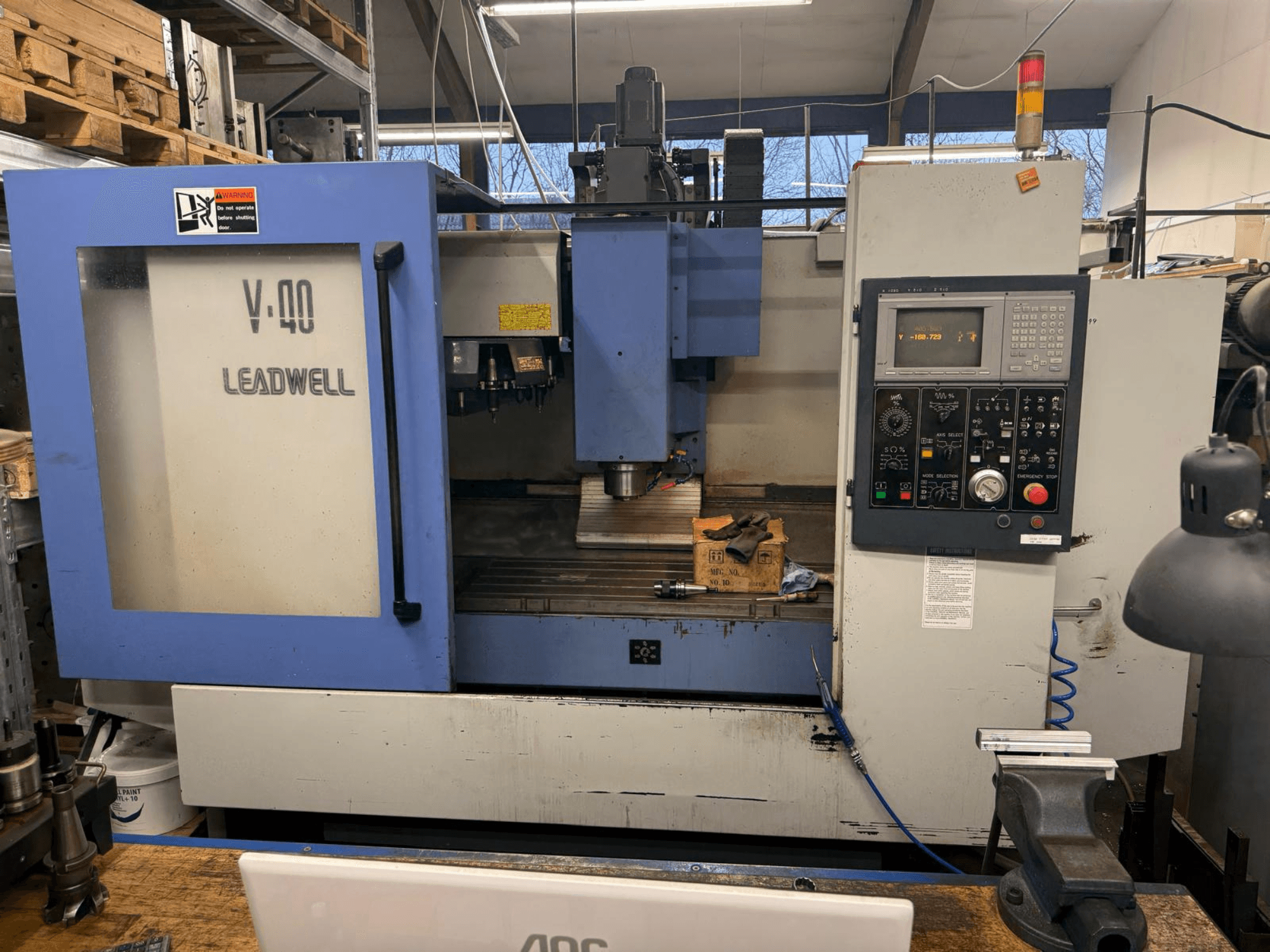 CNC glodalica LEADWELL V-40, prednji pogled, s upravljačkom pločom, alatima za rezanje i škripcem na radnom stolu.
