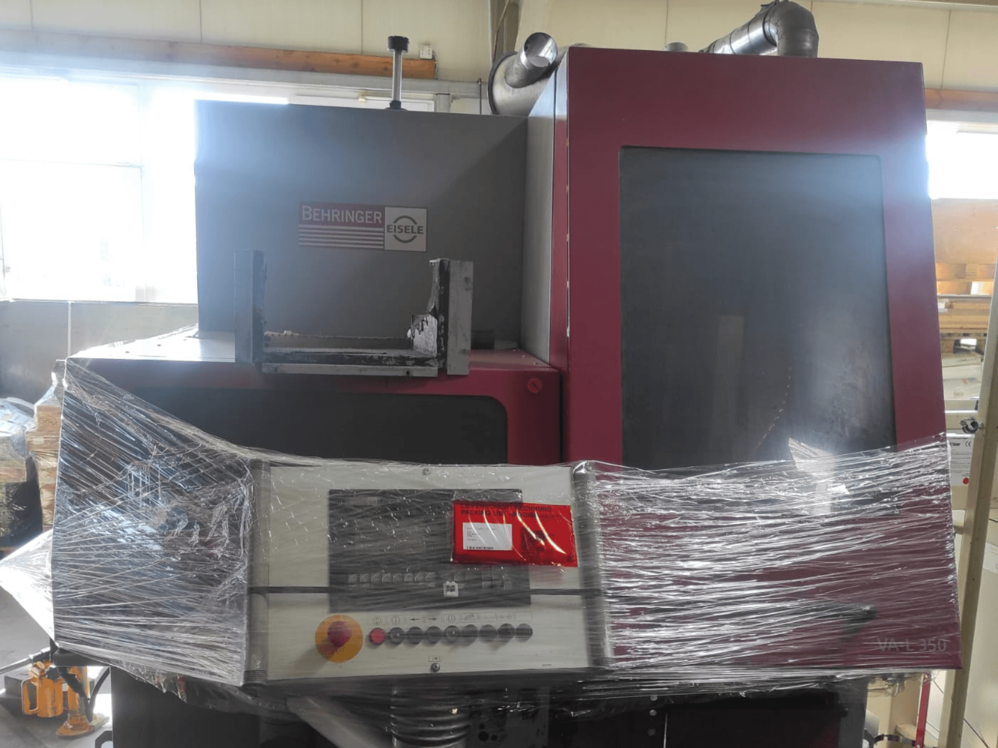 Behringer Eisele VA L 560 stroj, pogled sprijeda, omotan plastikom, s vidljivom upravljačkom pločom i gumbima.