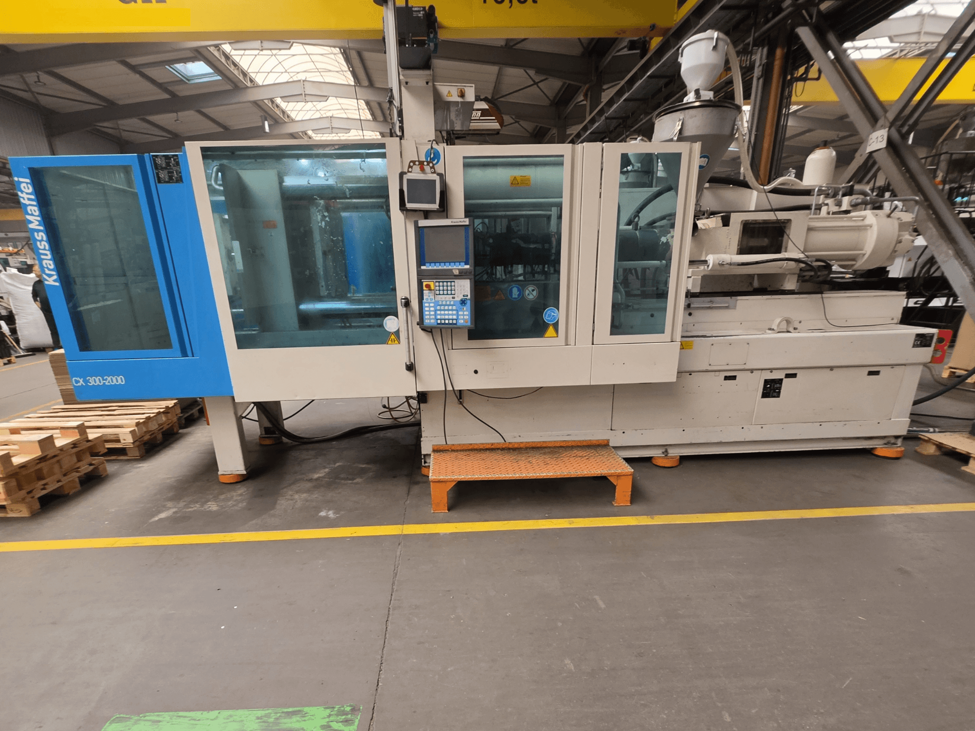 Krauss Maffei 300-2000 CX hidraulički stroj za brizganje plastike, bočni pogled s upravljačkom pločom i velikim prozorima.