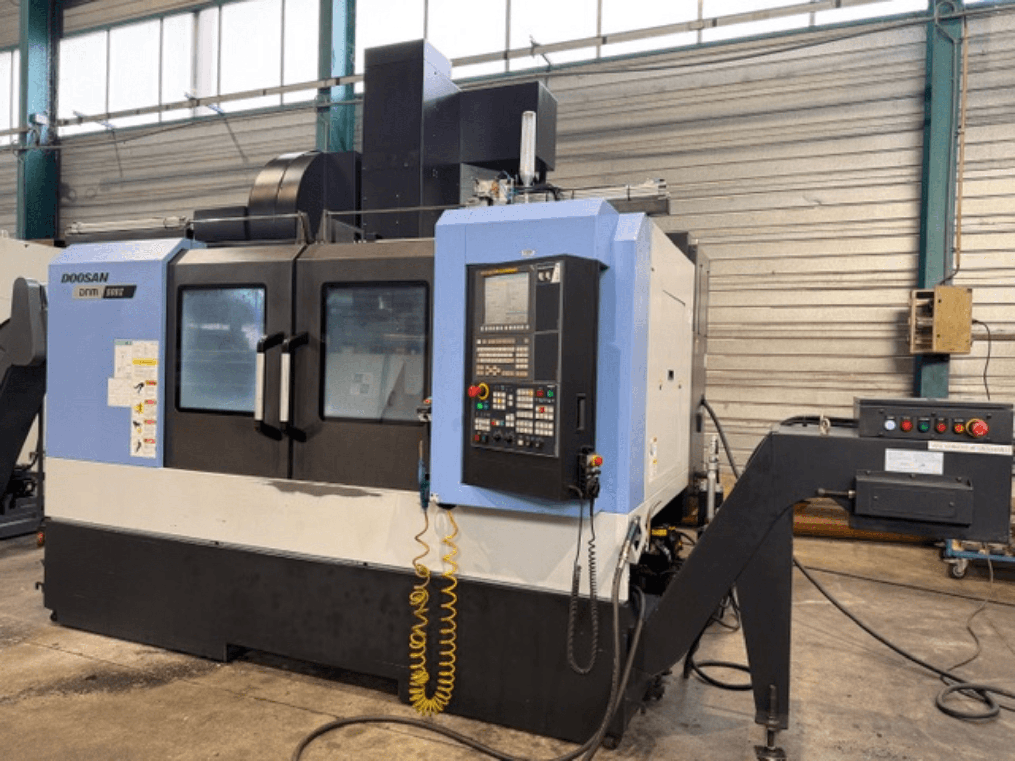 Doosan DNM 500II CNC glodalica s prednje strane, s upravljačkom pločom i držačem alata, u tvorničkom okruženju.