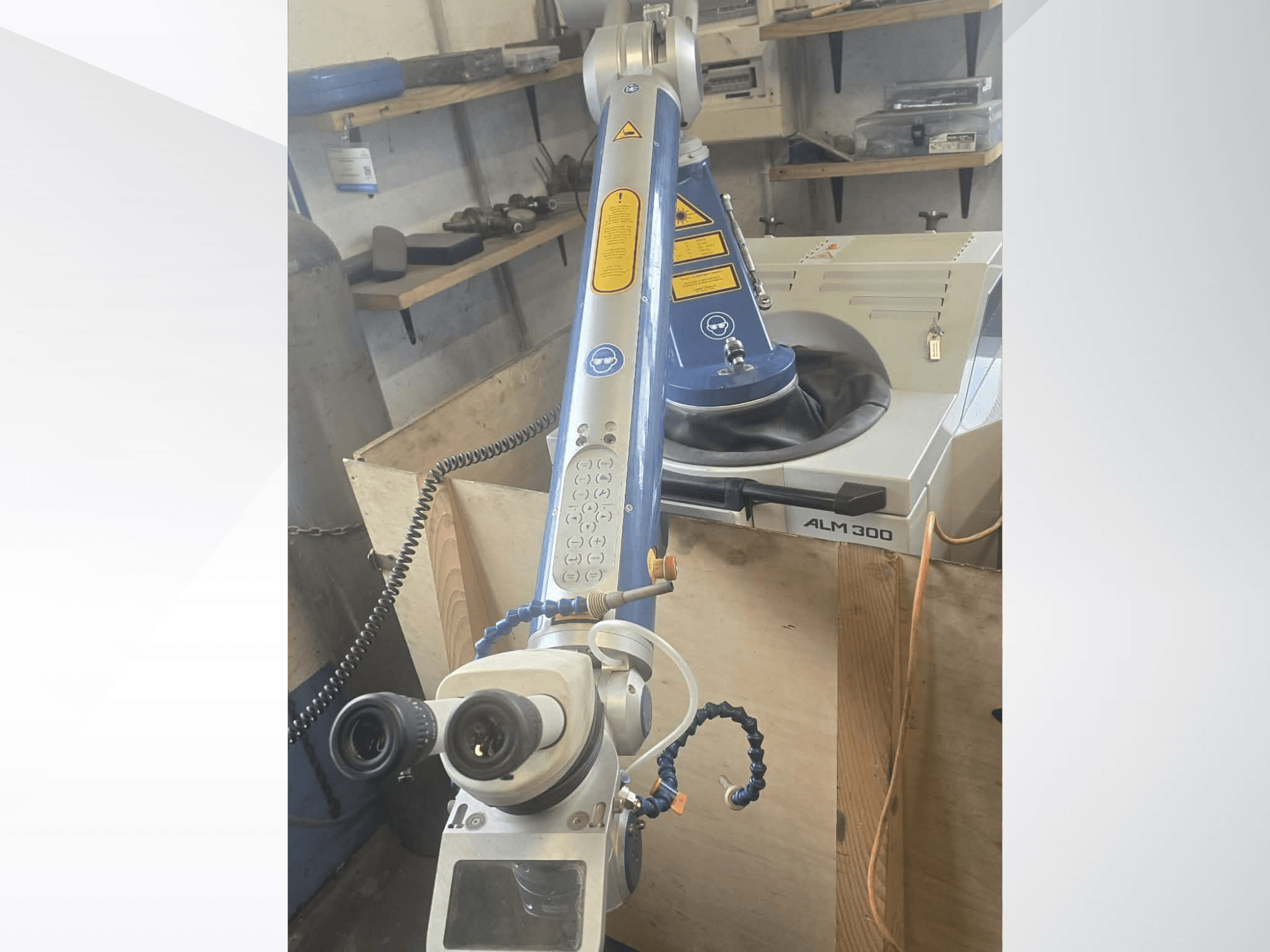 Prednji pogled na laserski stroj za zavarivanje ALPHA LASER ALM 300, s robotskom rukom, optičkim lećama i upravljačkom pločom.