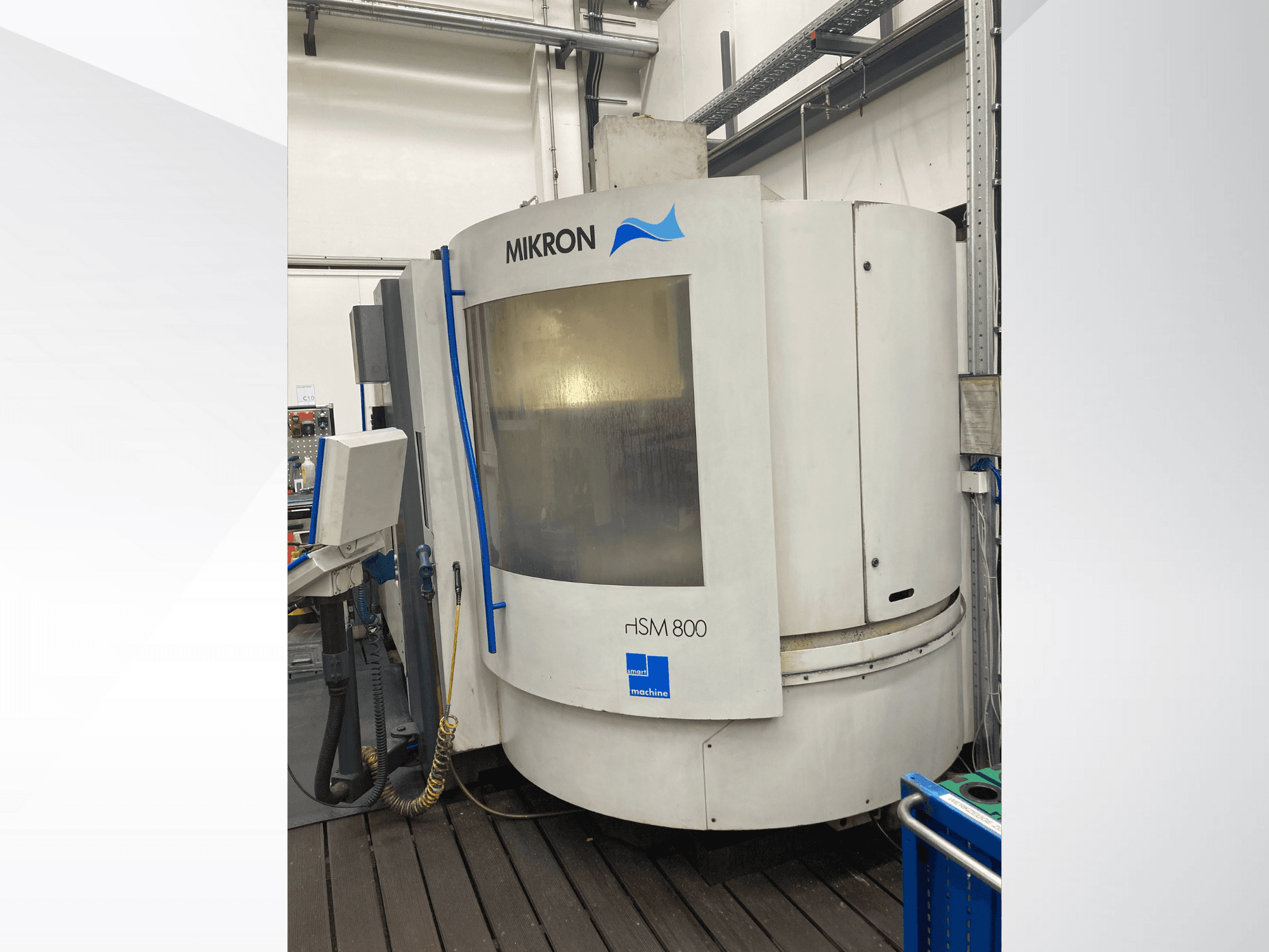 Mikron rISM 800 CNC stroj, prednji pogled s upravljačkom pločom, cilindrični dizajn i plavi detalji, smješten u radioničkom okruženju.